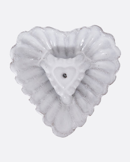 A white heart shaped incense holder, shown from the top.