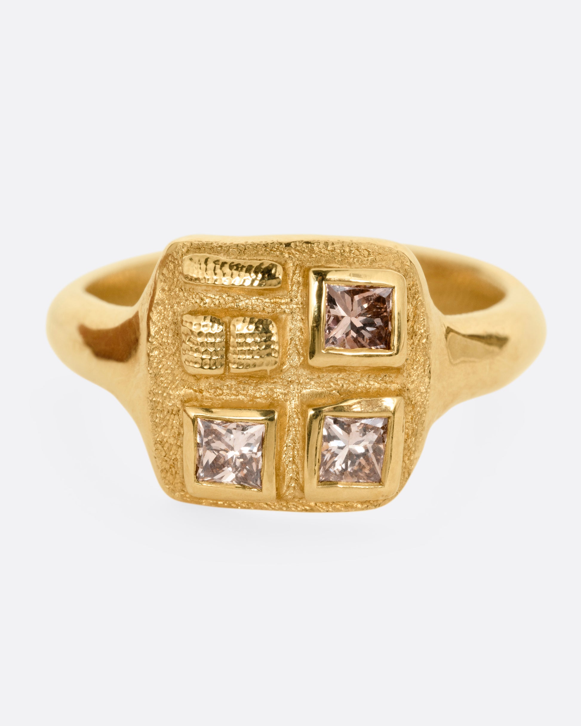 A yellow gold ring with three square diamonds on its square face, shown from the front.