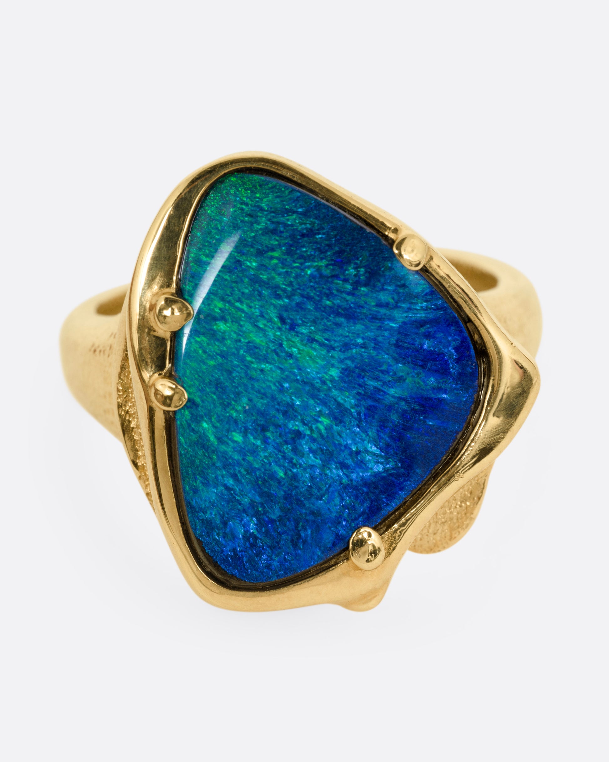 A yellow gold ring with a large boulder opal, shown from the front.