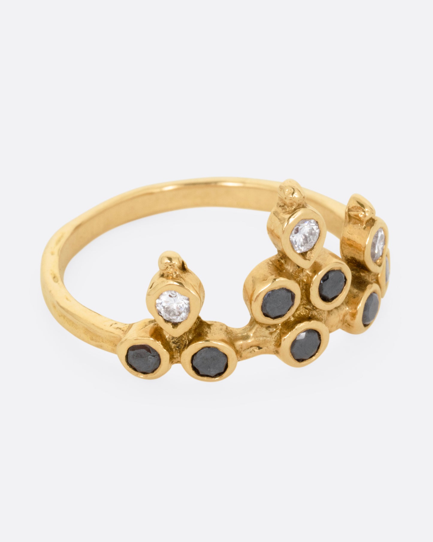 A yellow gold tiara ring with white and black diamonds, shown from the side.