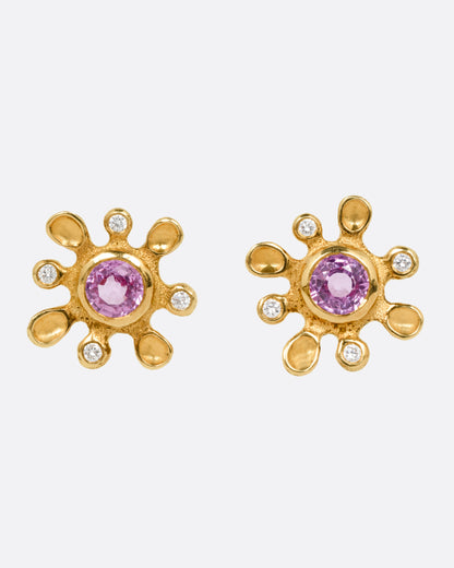 Yellow gold pink sapphire flower stud earrings, the pair from the front, each with a pink sapphire center and diamond-tipped petals