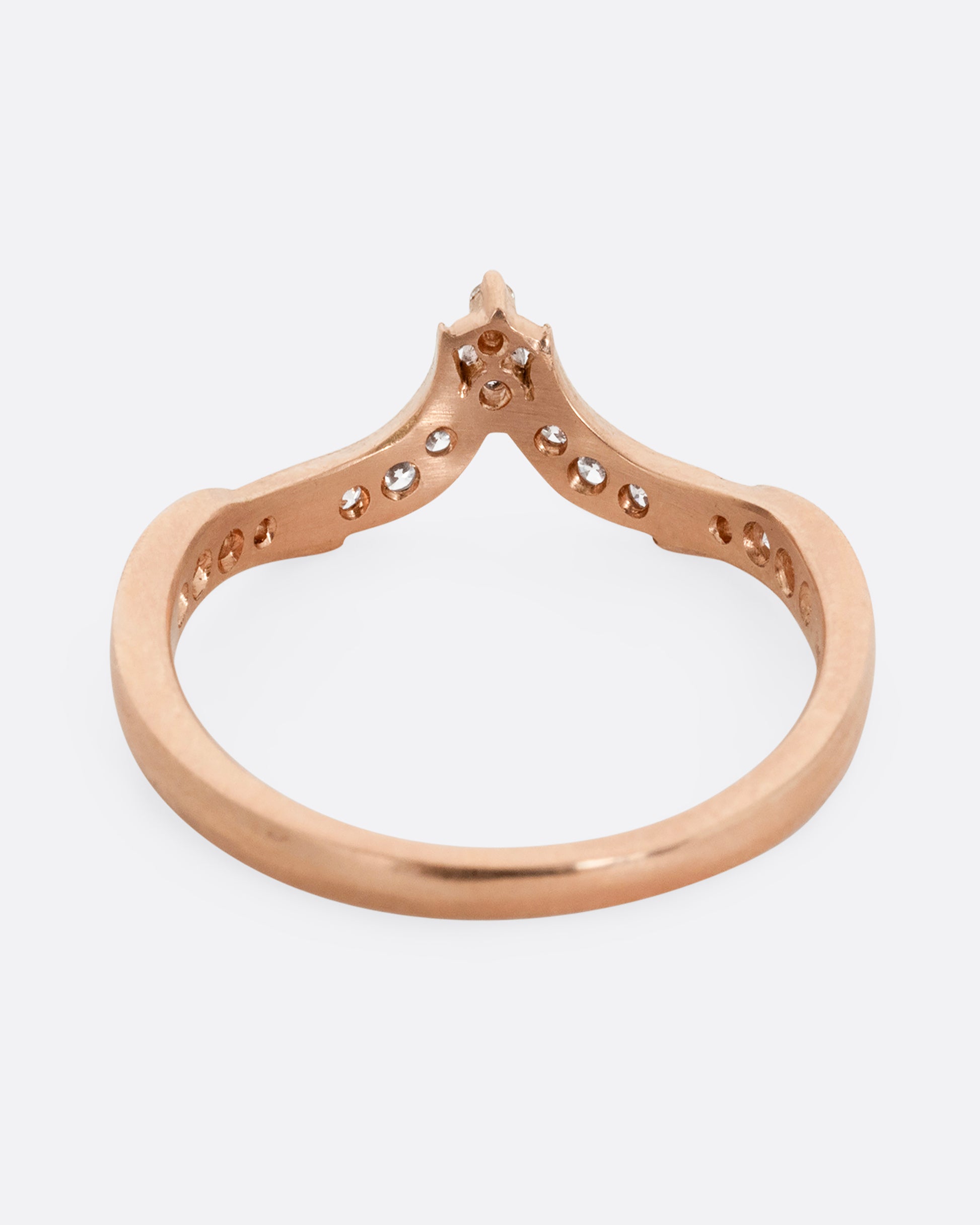A rose gold ring with tapering curves of pavé diamonds that come to a point at the center. Shown from the back.