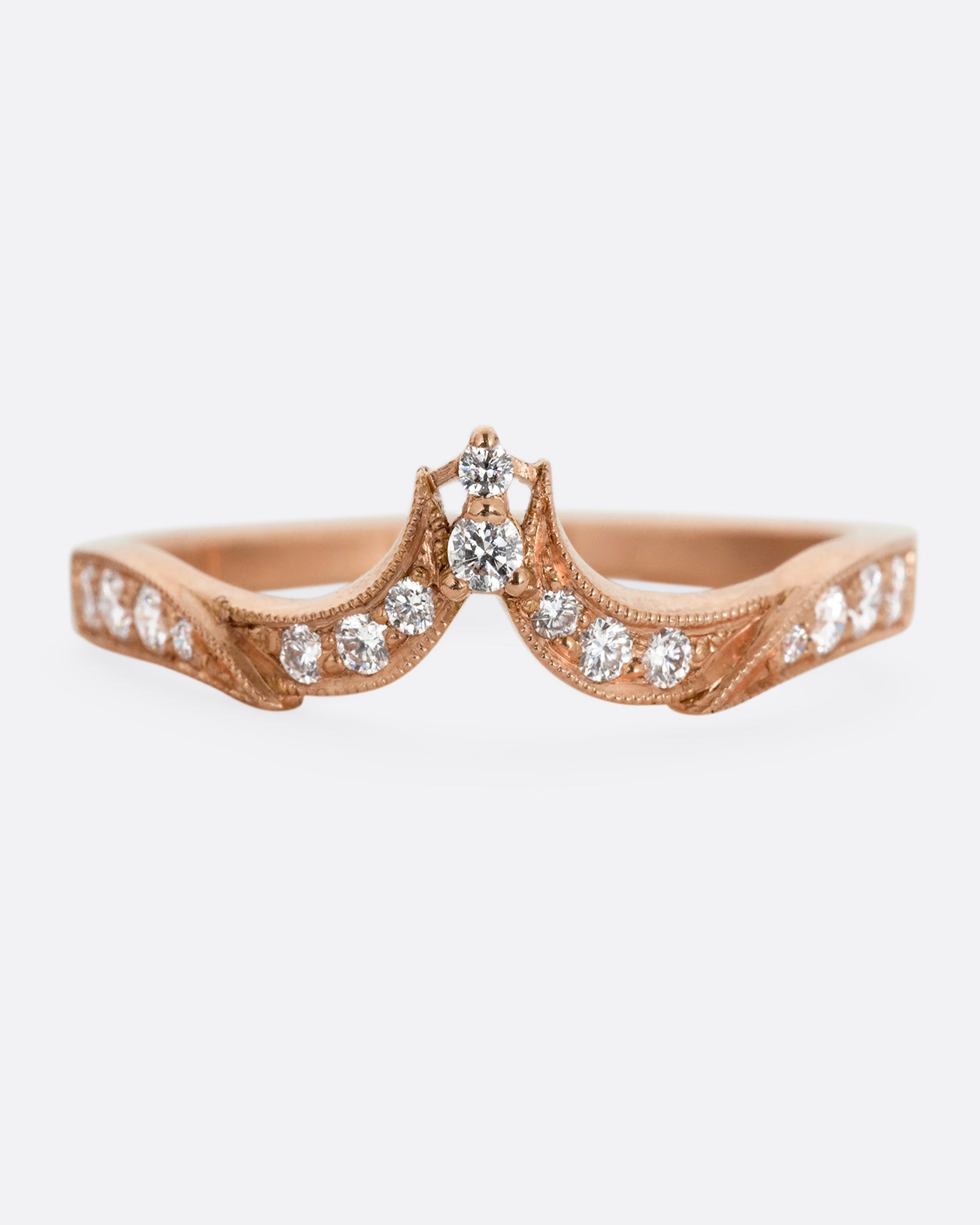 A rose gold ring with tapering curves of pavé diamonds that come to a point at the center. Shown from the front.