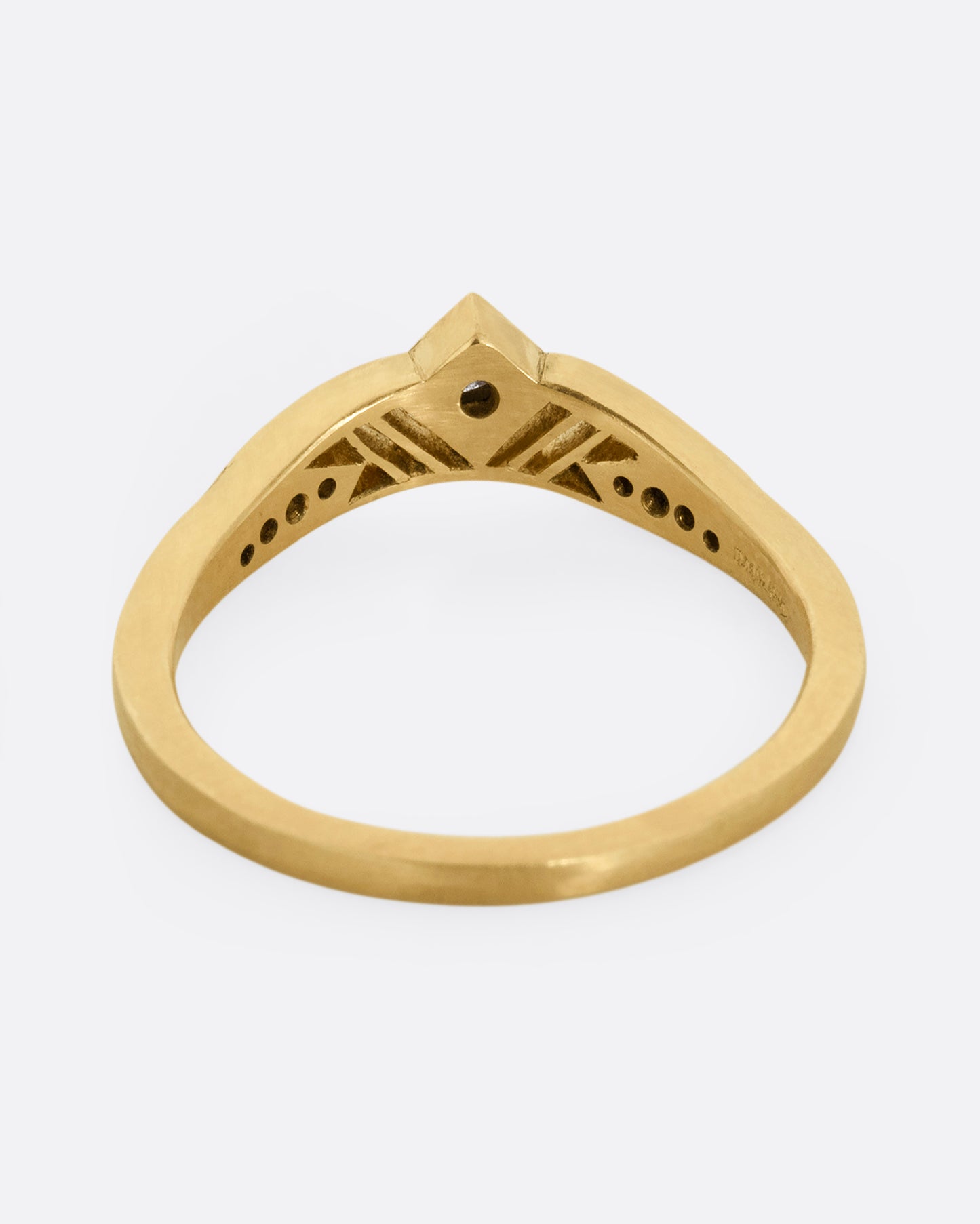 A subtly arched yellow gold ring with a diamond peak at the center flanked by graduated diamonds and cutouts. Shown from the back.