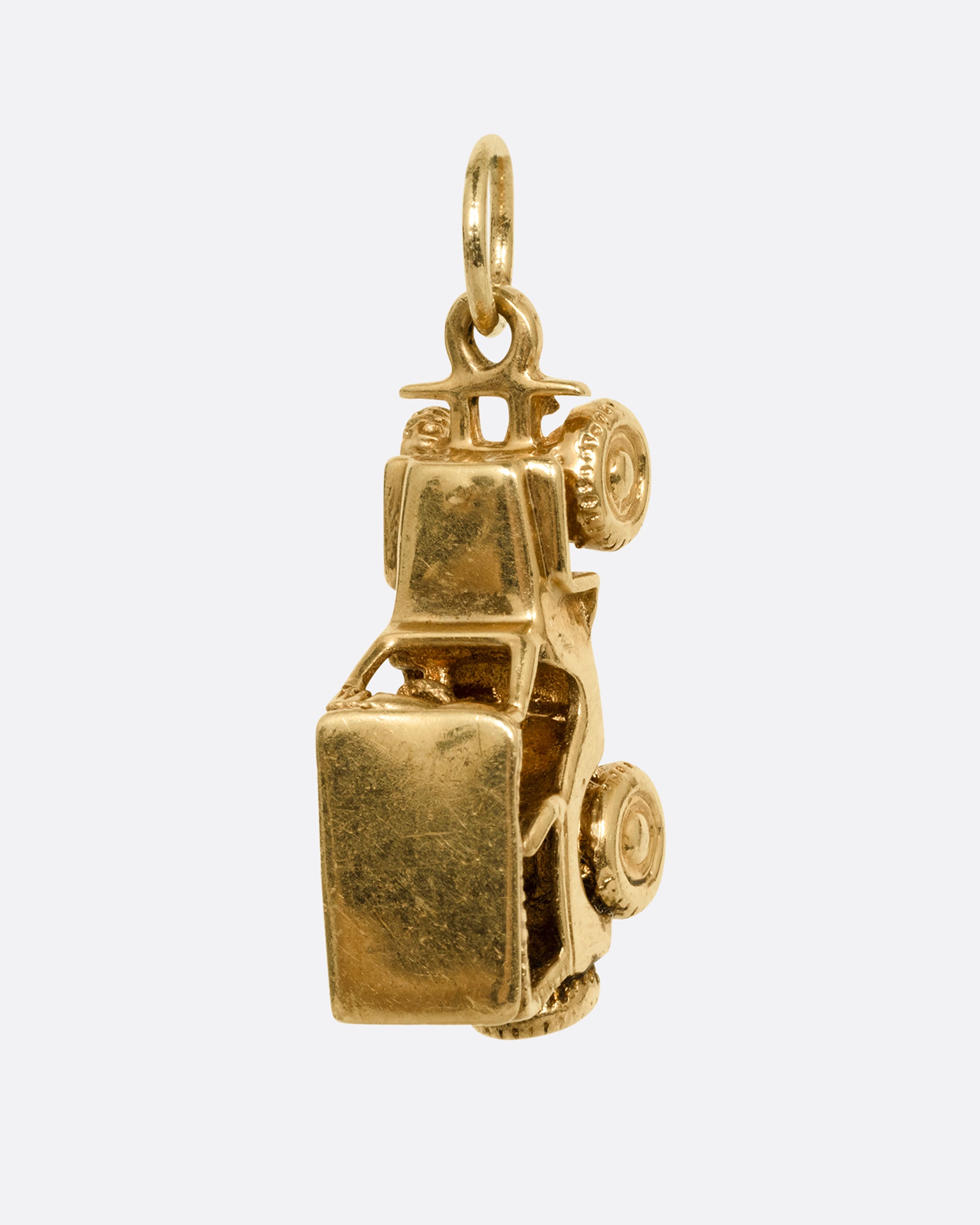 A yellow gold jeep charm. Shown standing up from the front.
