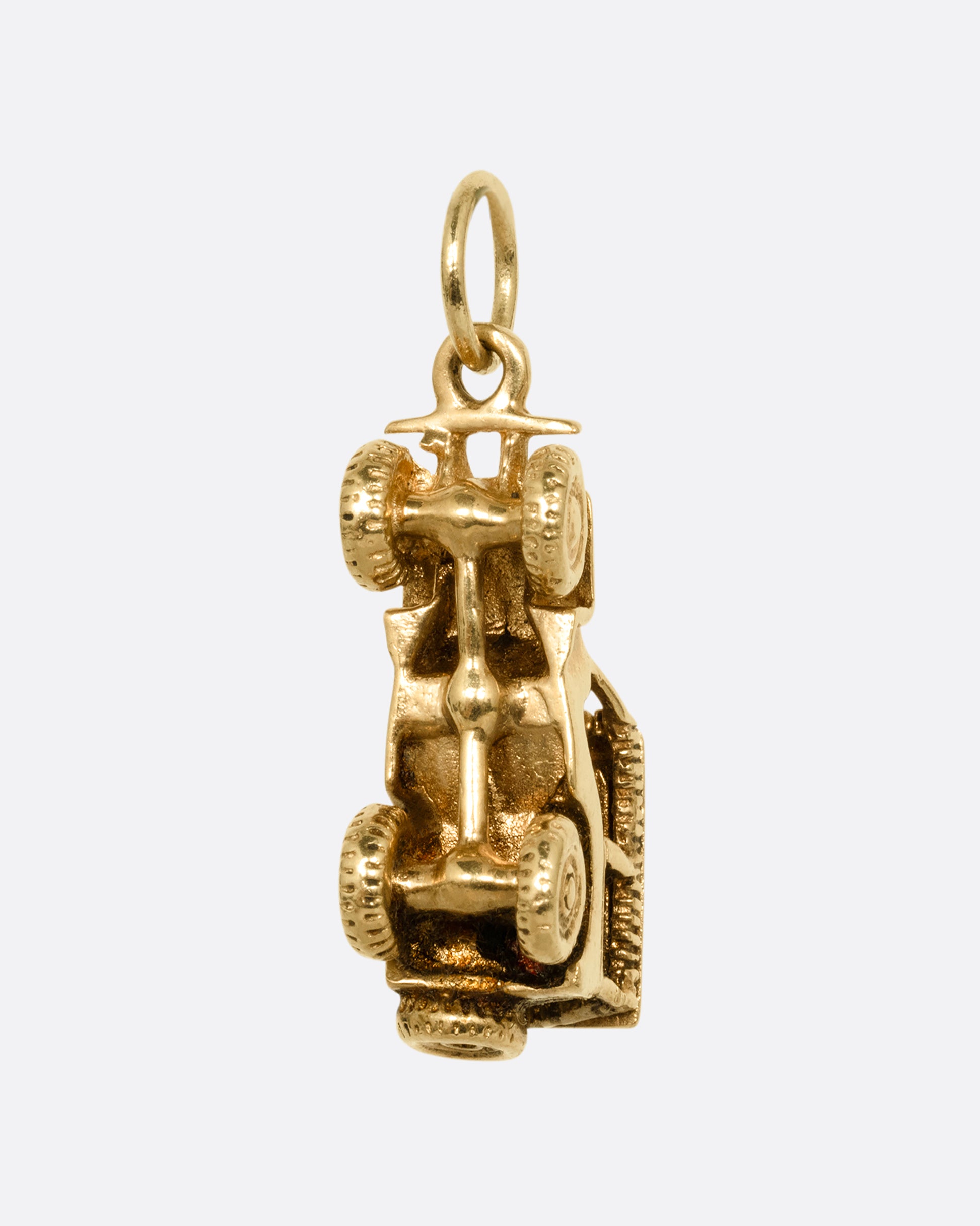 A yellow gold jeep charm. Shown standing up from the back.