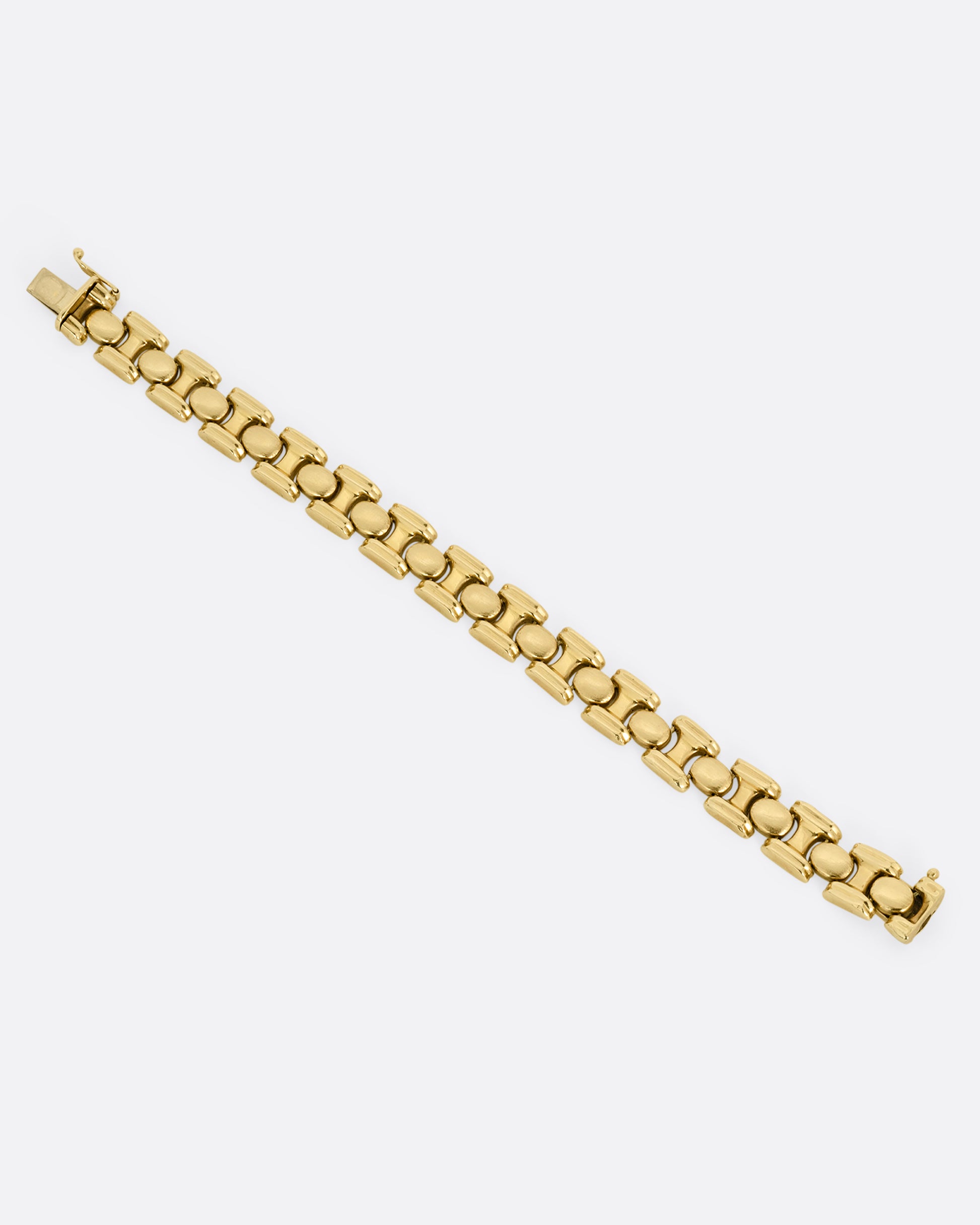 A  yellow gold bracelet with repeating oval sections. Shown from the top open and lying flat.