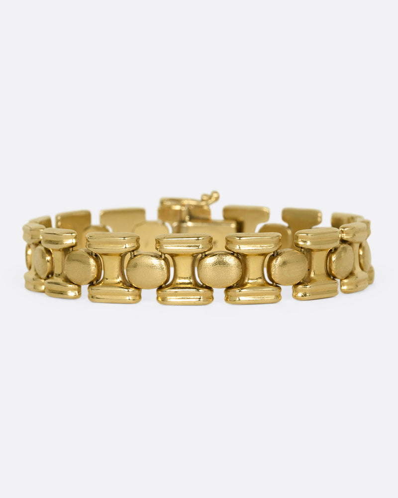 A yellow gold bracelet with repeating oval sections. Shown from the front.