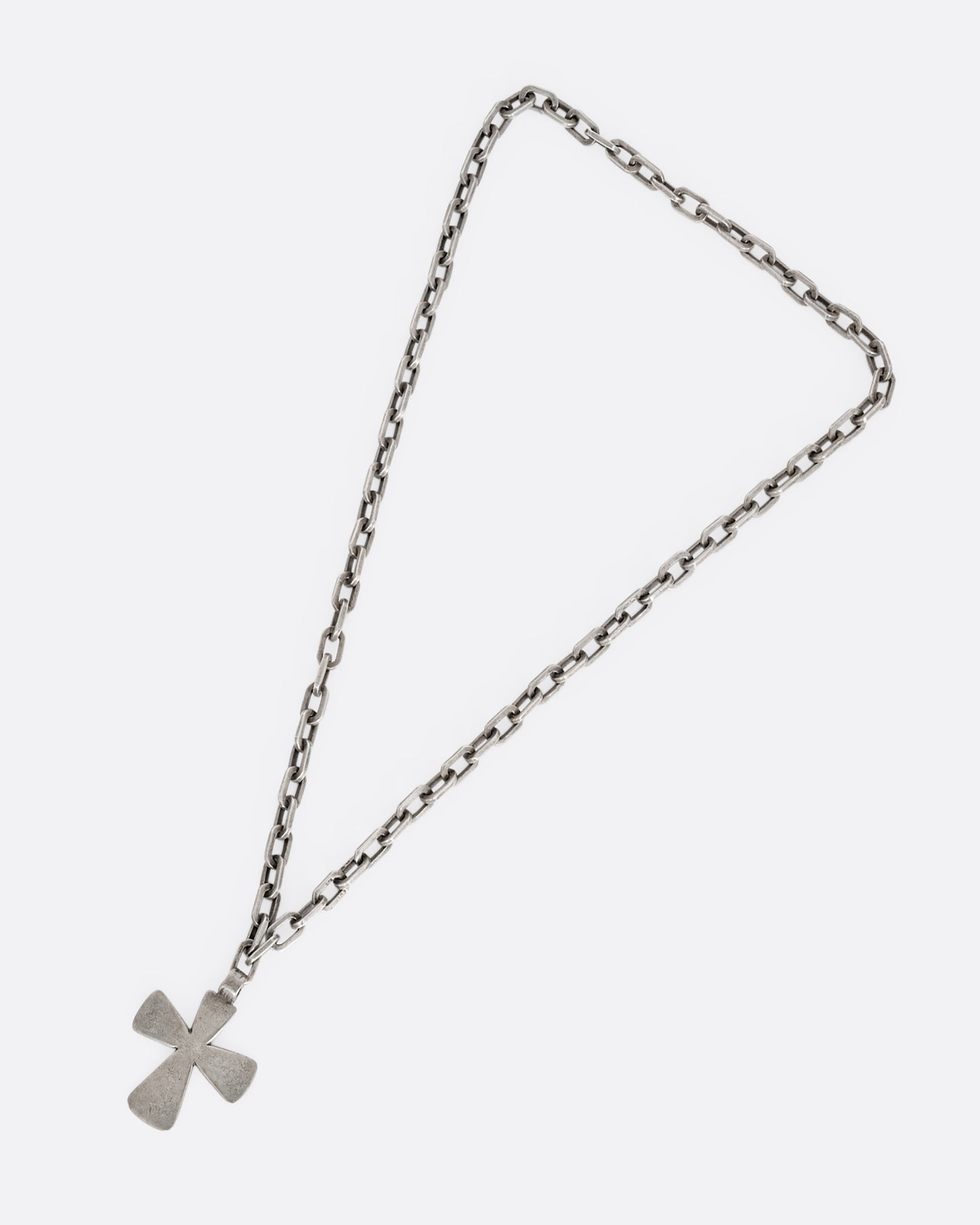 A heavy cable chain necklace with a large cross pendant. Shown lying flat from the front.