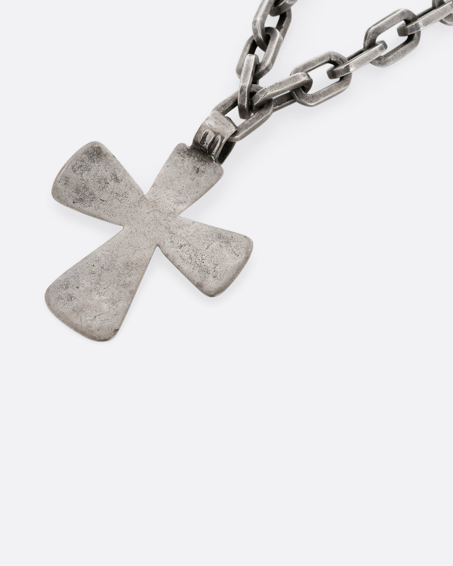 A heavy cable chain necklace with a large cross pendant. Shown up close from the side.