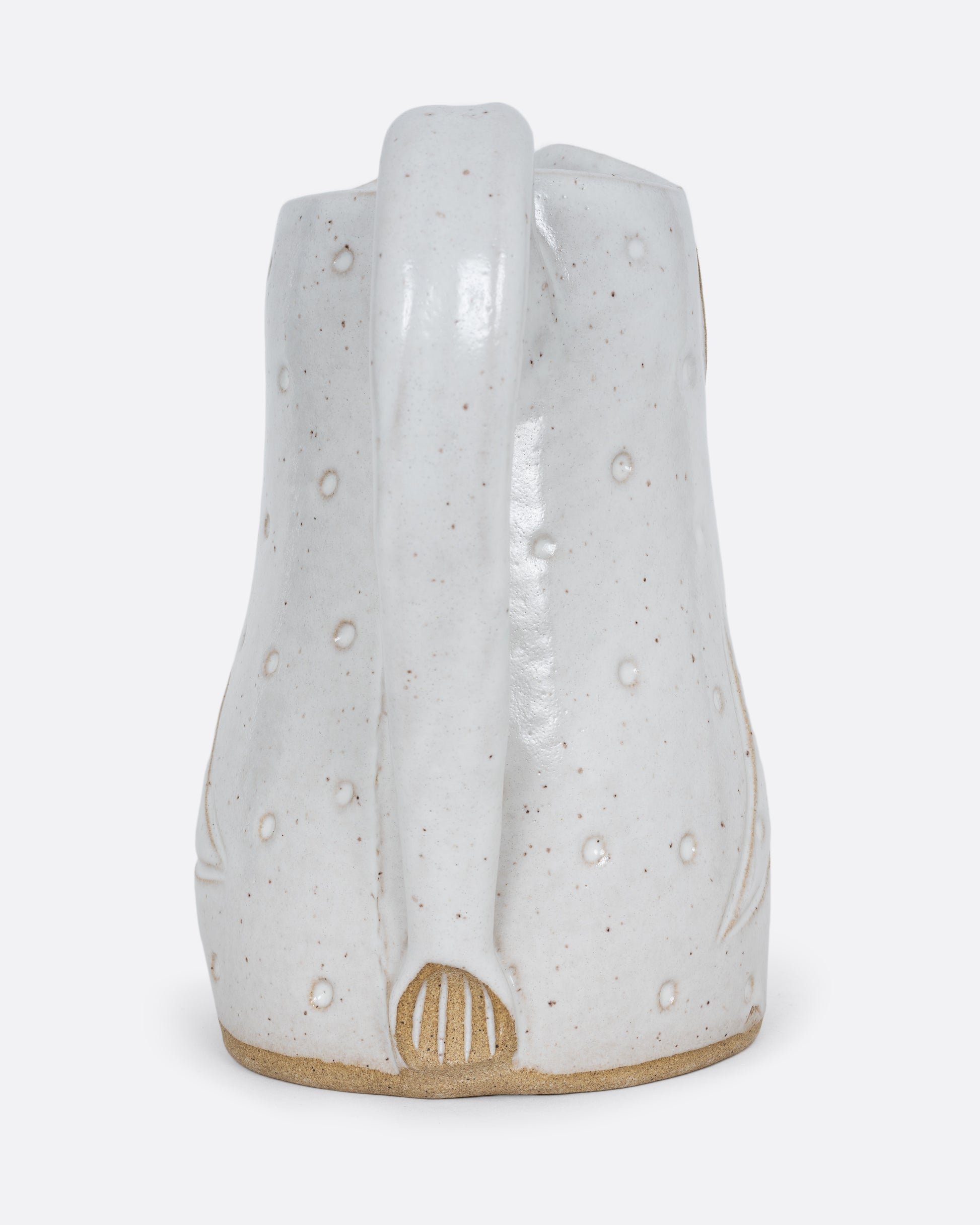 A white bird shaped pitcher with a handle. Shown from the back.