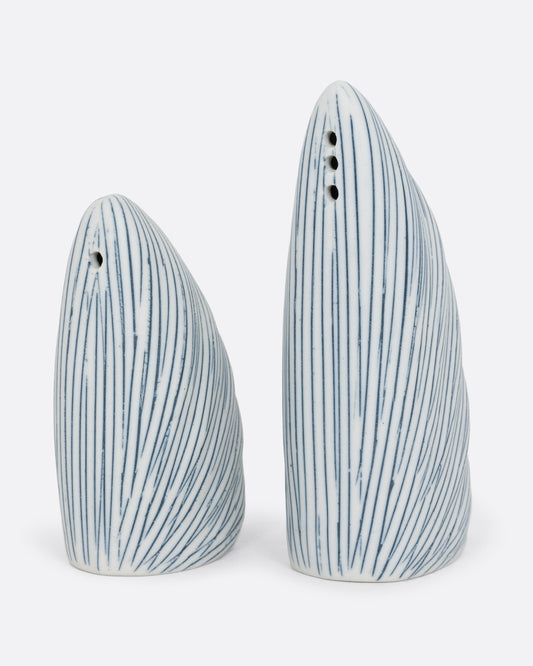 A pair of triangular white and blue striped pair of salt and pepper shakers. The shorter shaker has one whole, the taller has three. Shown from the front.