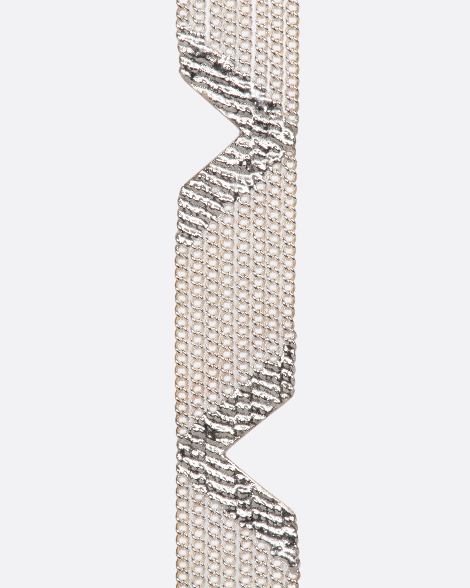 A sterling silver bracelet made out of multiple strands of chain, held together by solid sections of silver solder, with triangular cutouts along each side.