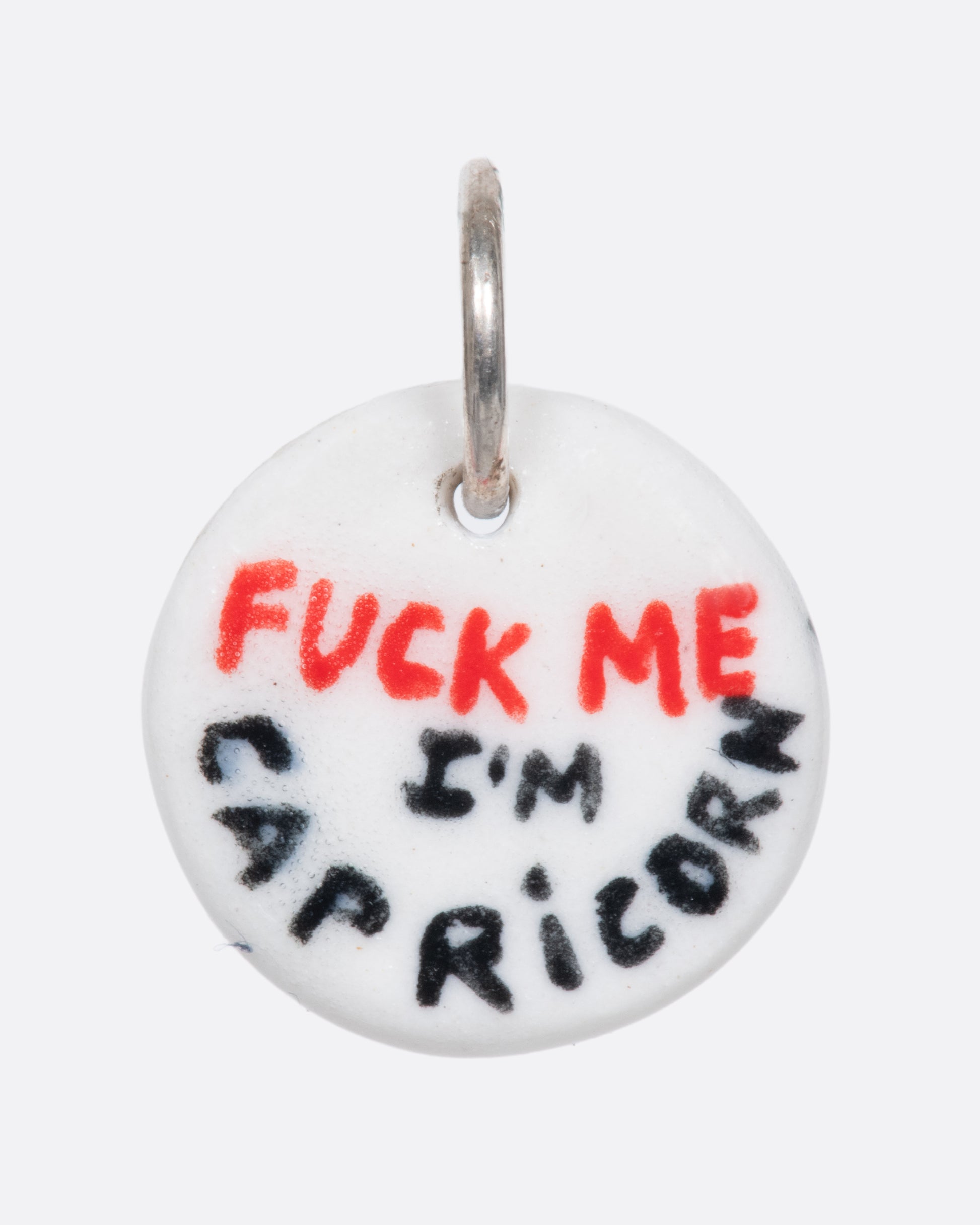 A handmade and painted porcelain zodiac disc charm with a sterling silver bail, featuring a sex position specific to each zodiac.