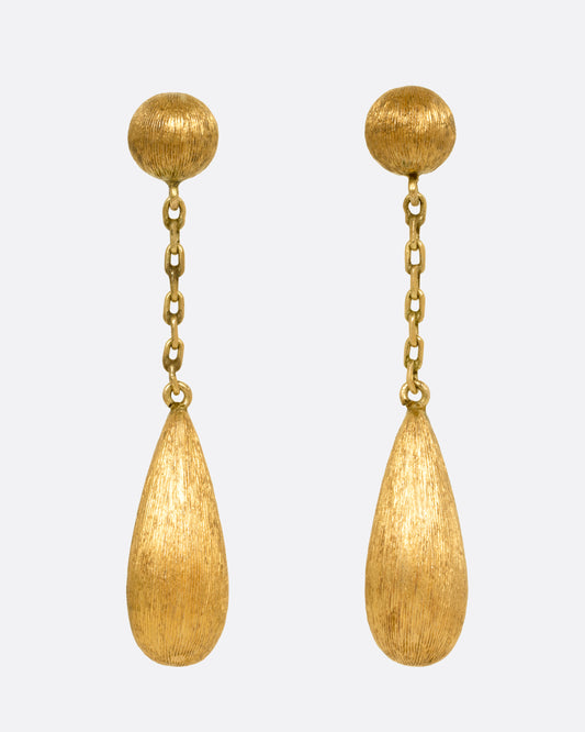 A pair of yellow gold teardrop shaped earrings, shown from the front.