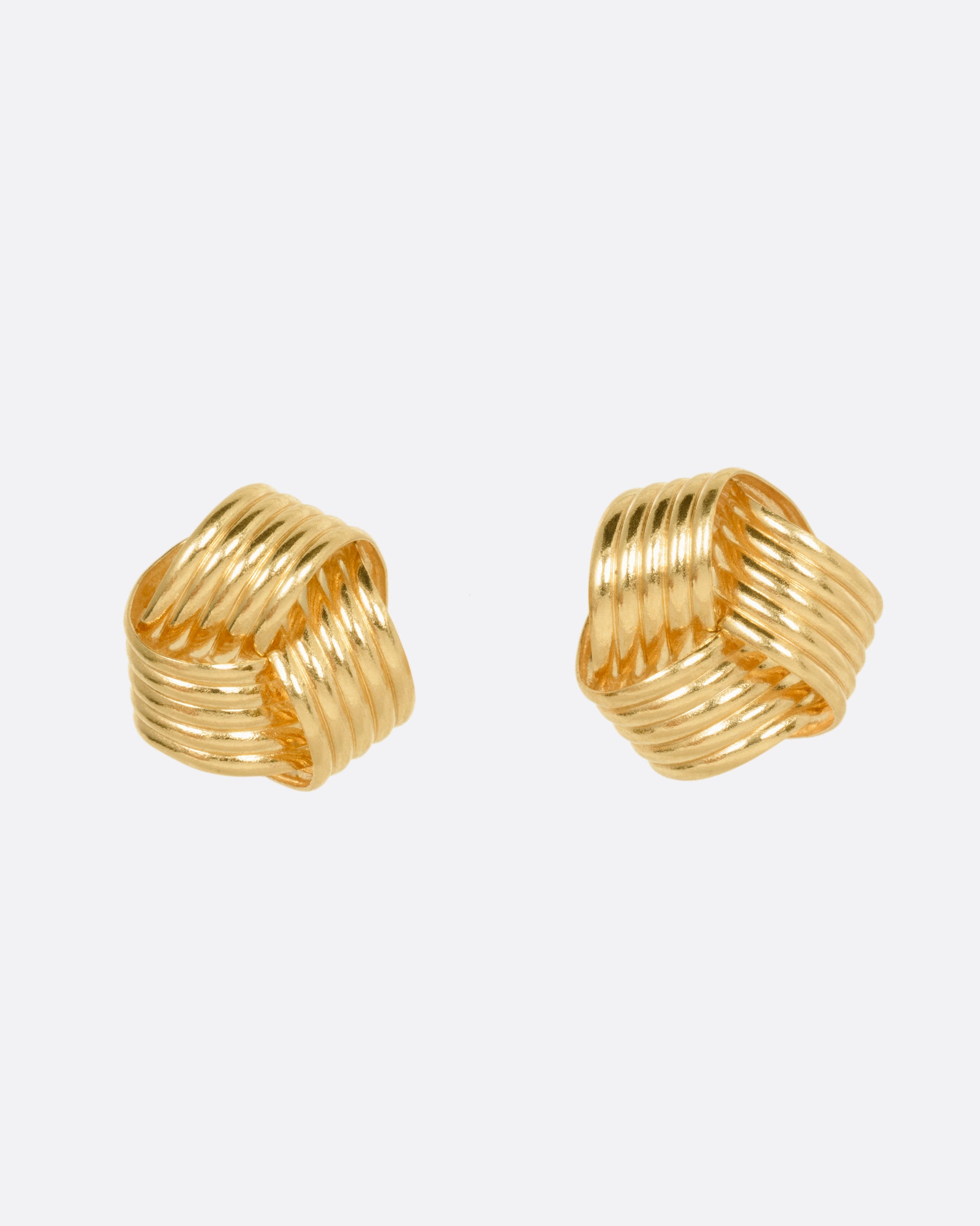 A pair of knot shaped yellow gold stud earrings, shown from the front.
