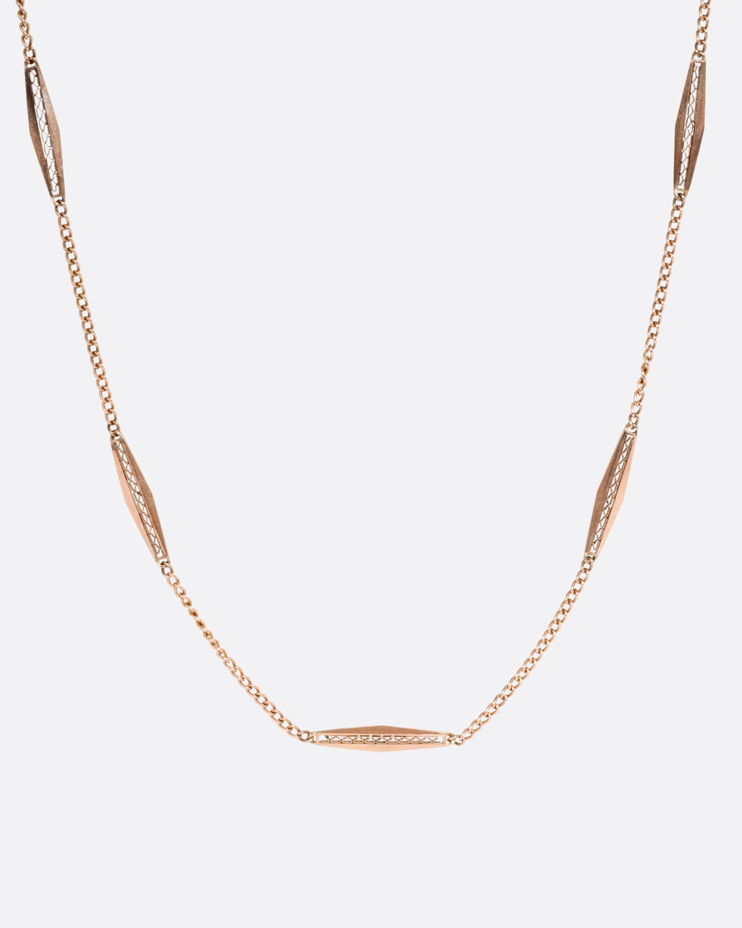 A rose gold bar link necklace shown from the front.