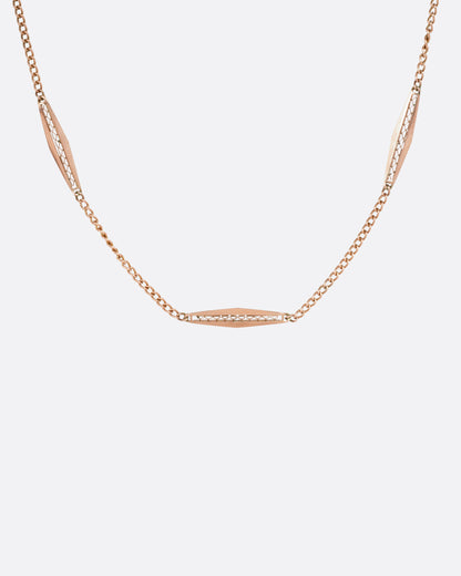 A rose gold bar link necklace shown from the front.