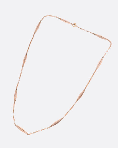 A rose gold bar link necklace shown from the front.