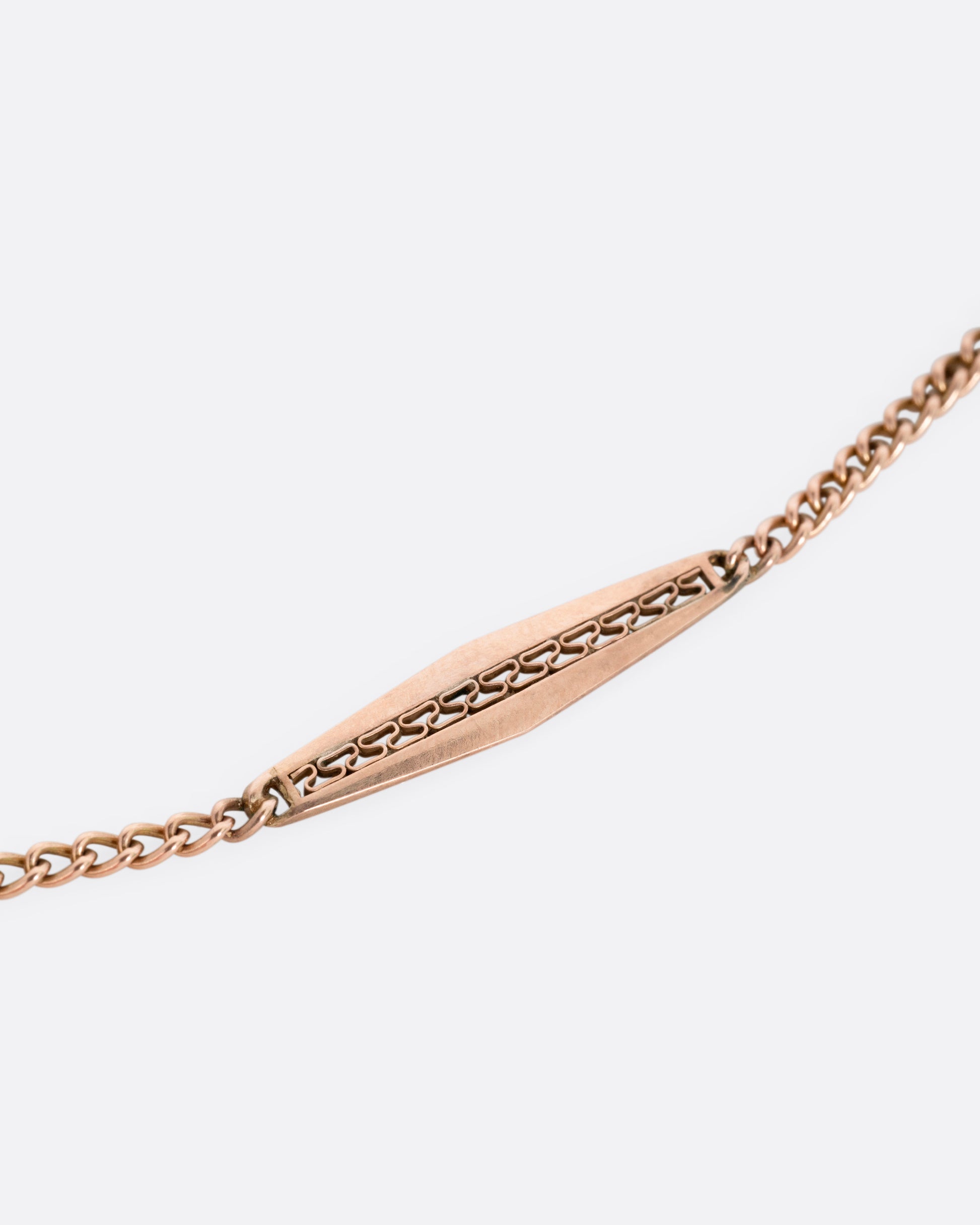 A close up of a rose gold bar link necklace.
