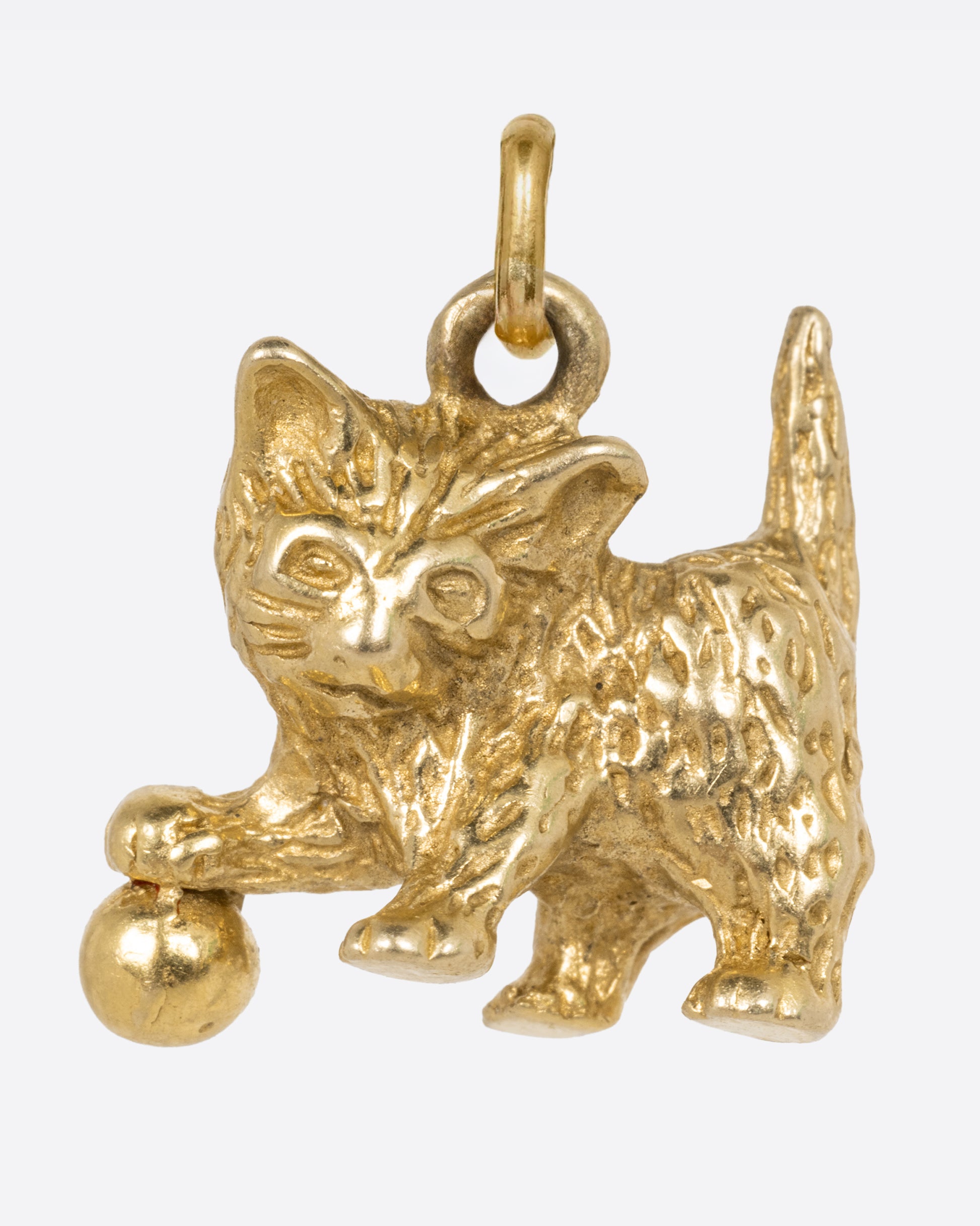 A yellow gold kitten charm with a ball, shown from the front.