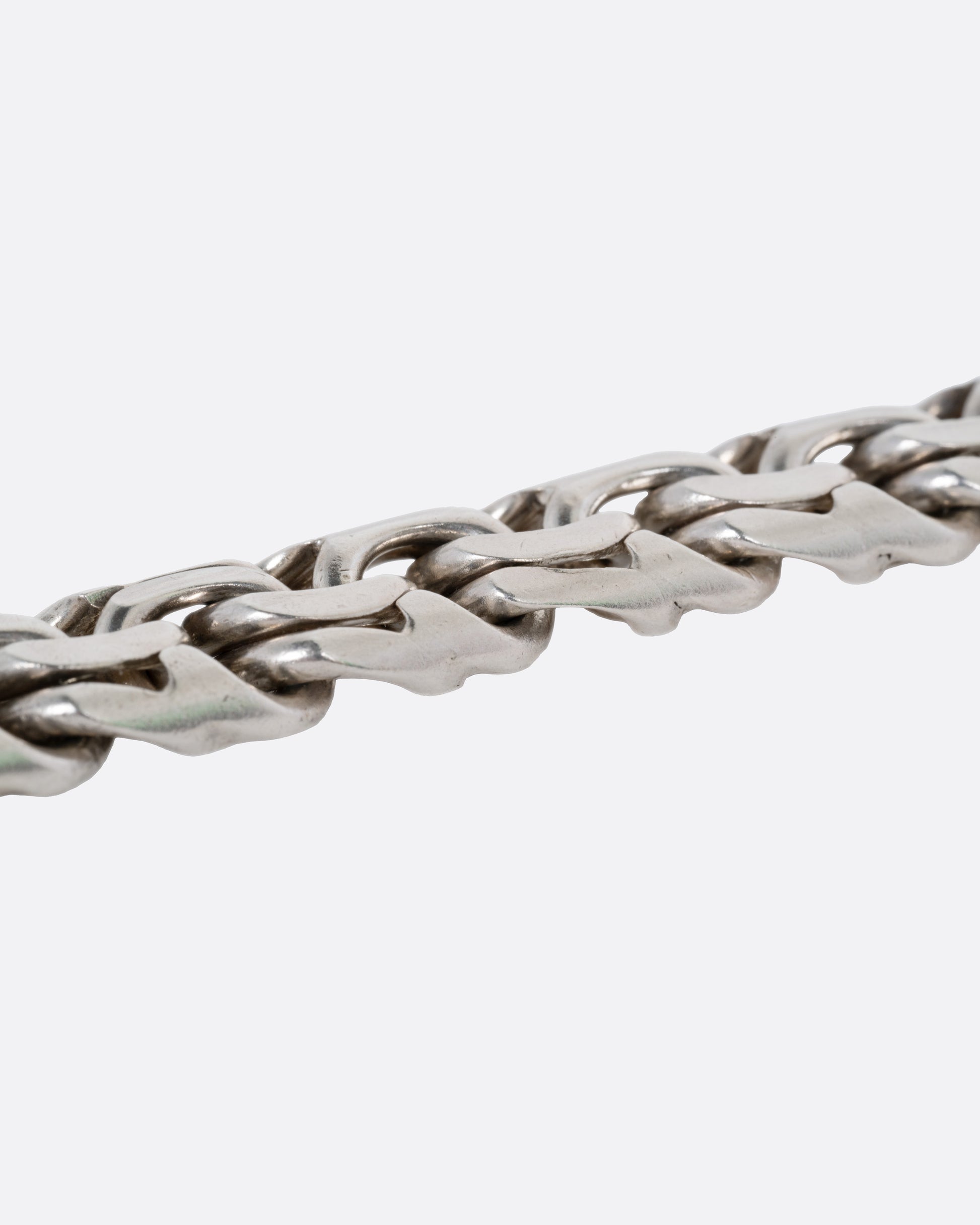 A close up of a silver flat double link bracelet.