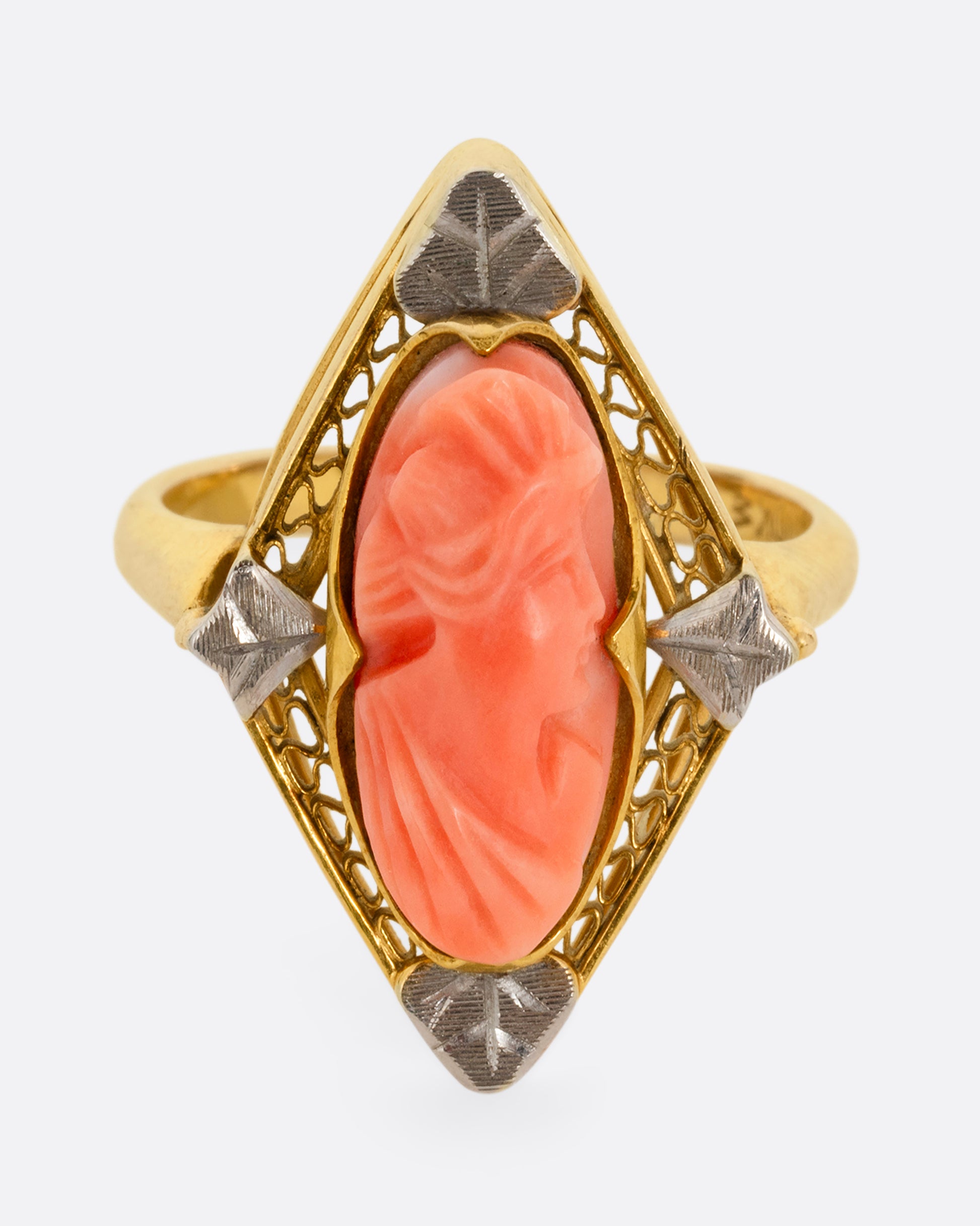 A yellow gold cameo ring with a coral carved portrait. Shown from the front.