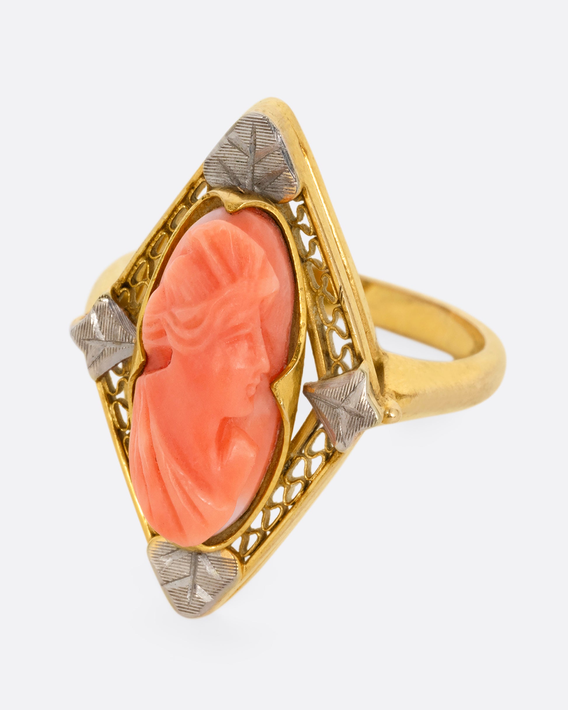 A yellow gold cameo ring with a coral carved portrait. Shown from the front.