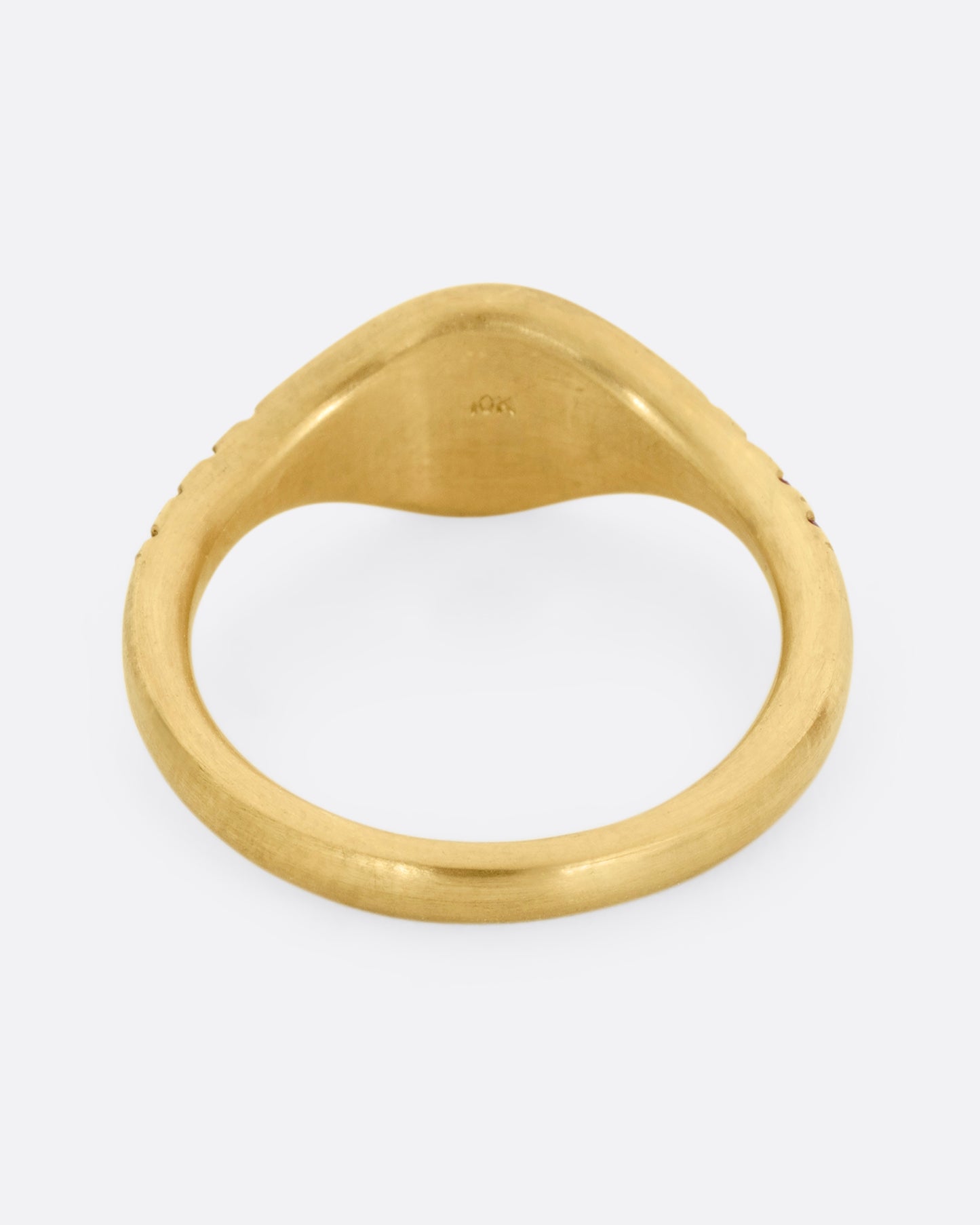 A yellow gold signet ring with rubies on the shoulders. Shown from the back.