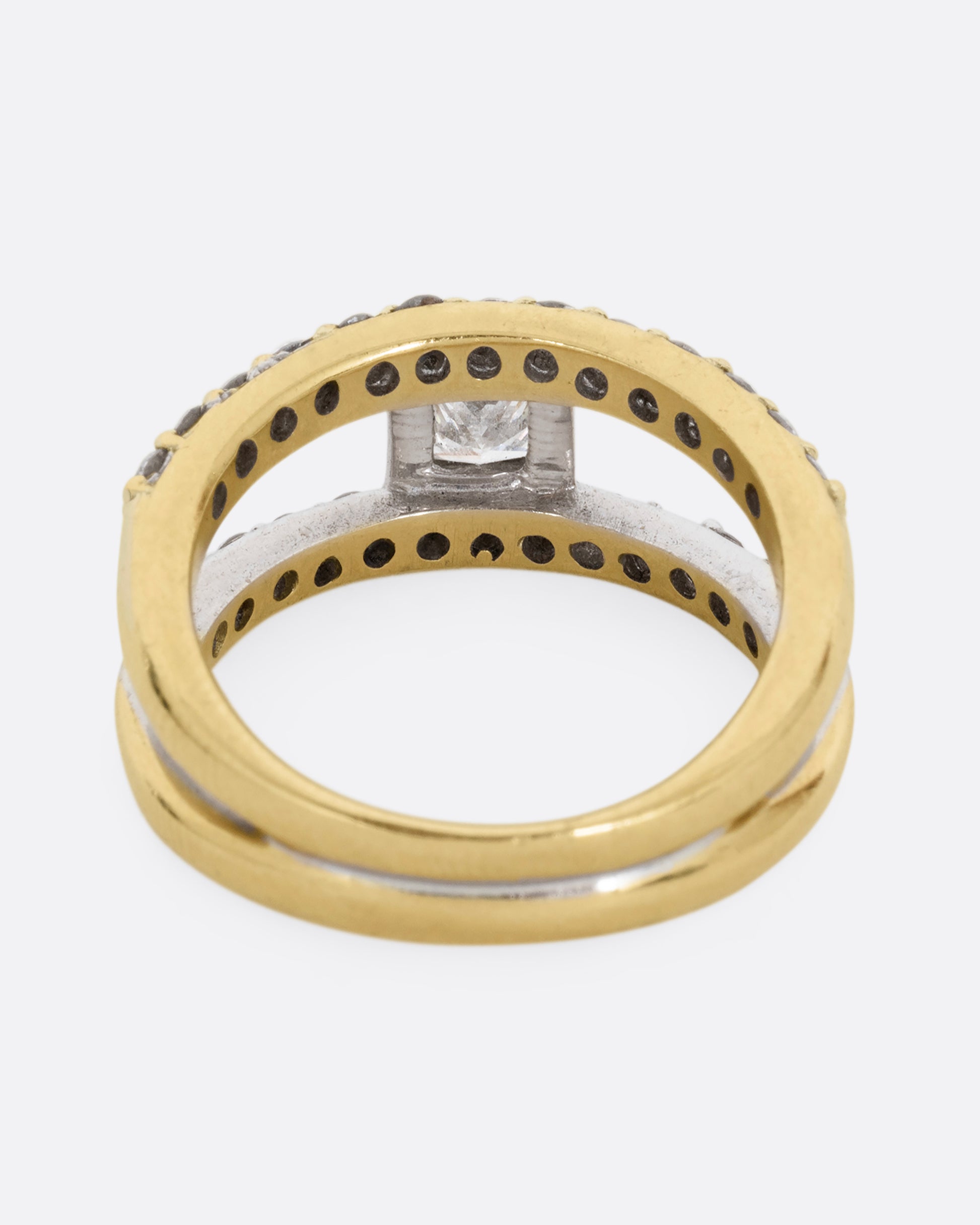 A yellow and white gold double band with pave diamonds and a center princess cut diamond. Shown from the back.