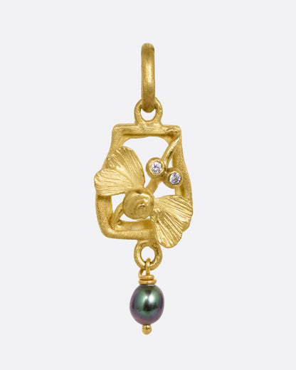 A yellow gold diamond eyed dragonfly charm with a keshi pearl. Shown from the front.
