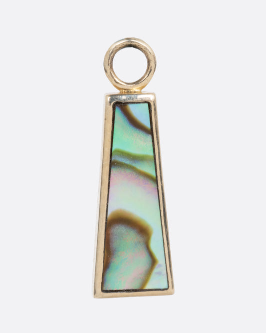 A yellow gold trapezoid dangle with abalone inlay. Shown from the front.