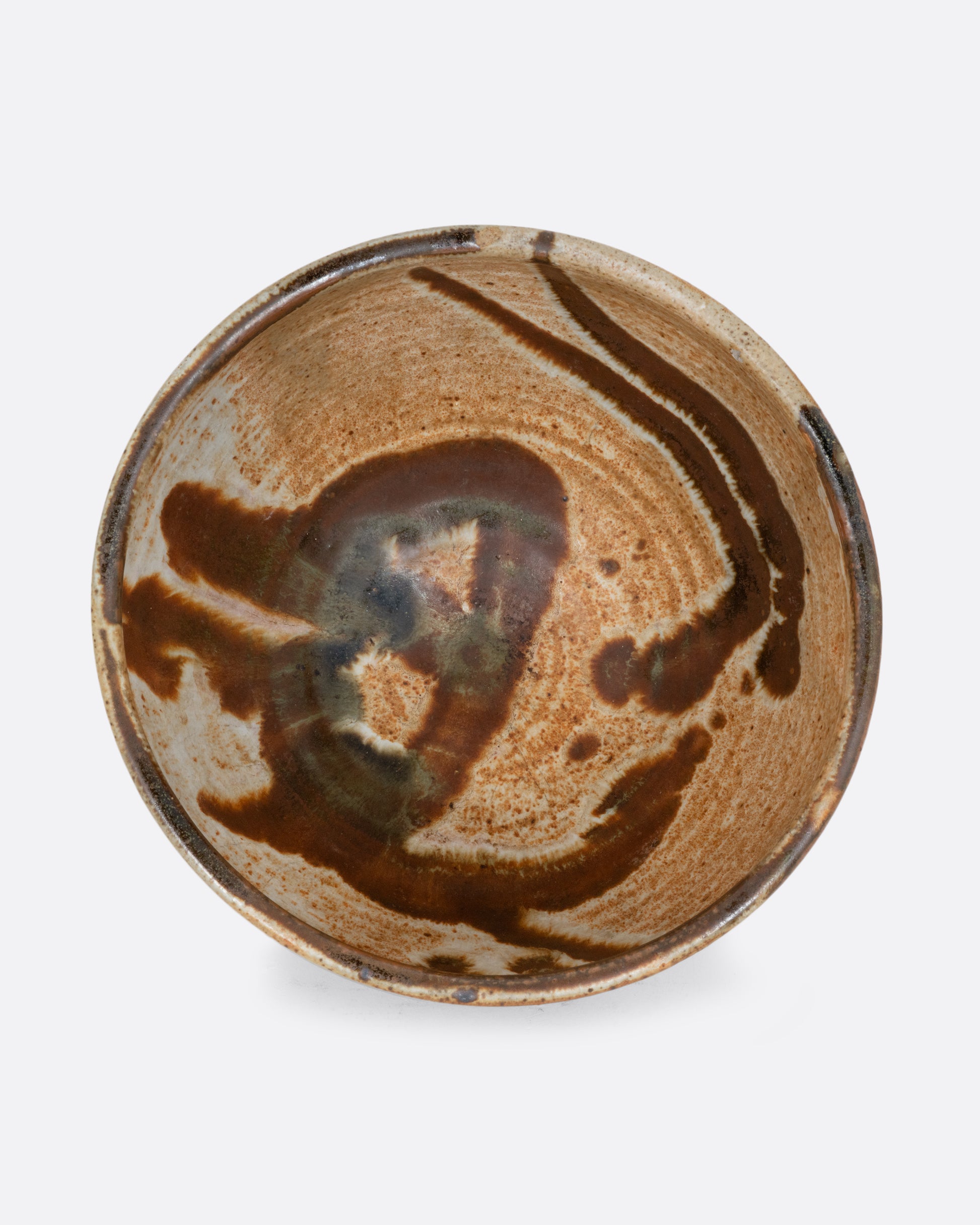 A brown bowl with brown brushstrokes all over. Shown from the top.