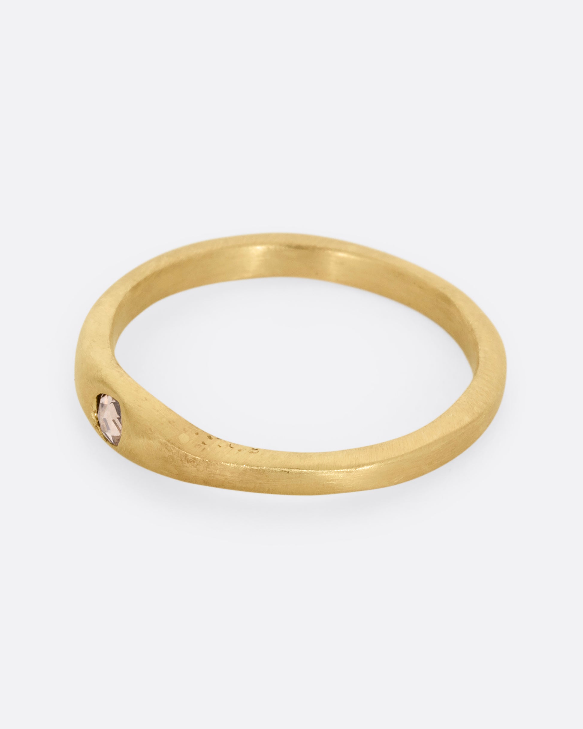 A yellow gold ring with a rose cut diamond. Shown from the side.