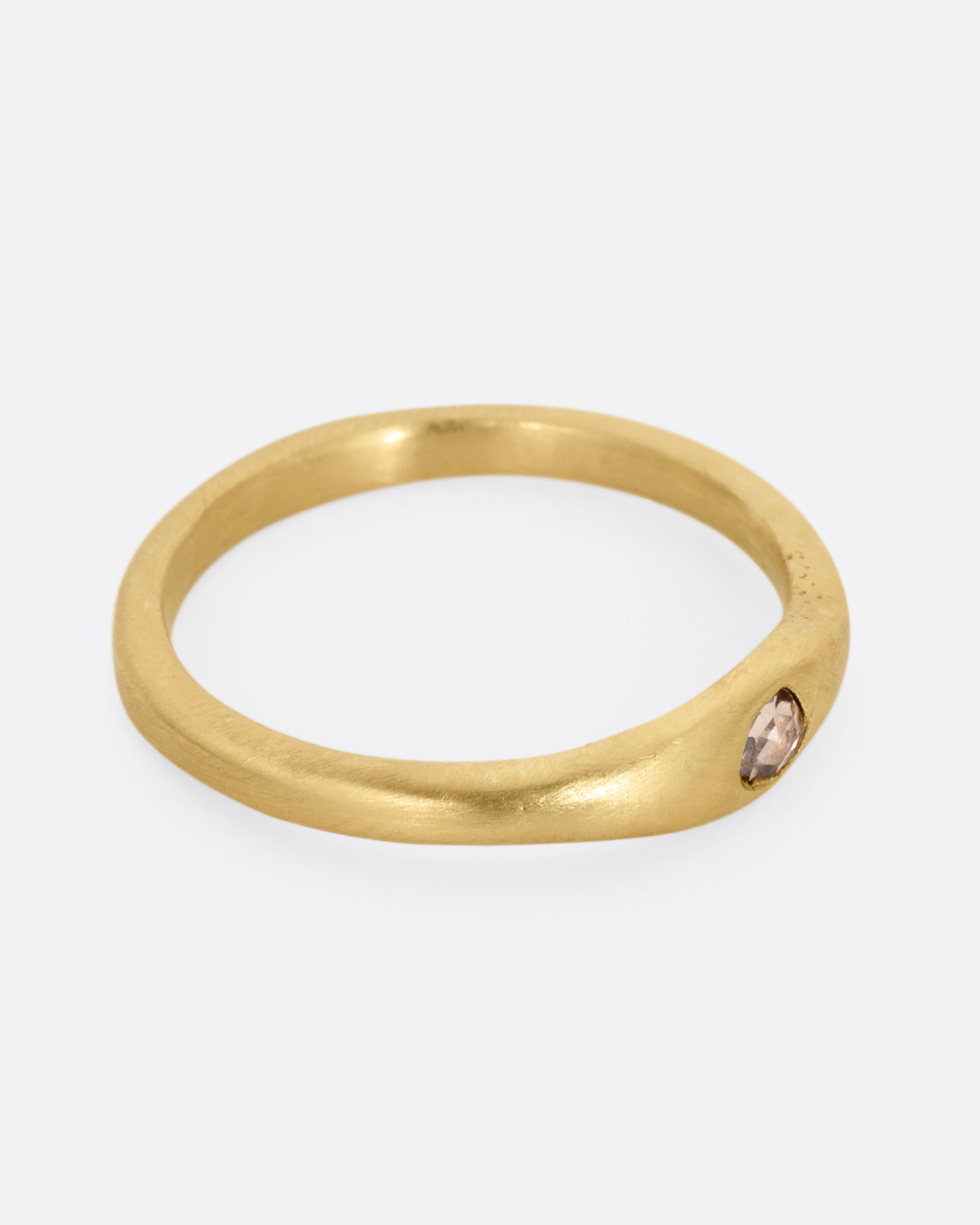 A yellow gold ring with a rose cut diamond. Shown from the side.