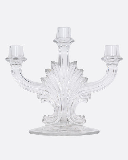 A clear glass candelabra with three holders, shown from the front.