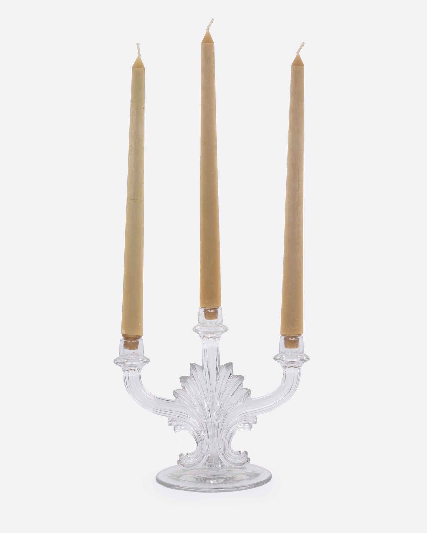 A clear glass candelabra with three holders, shown from the front with candles in each arm.