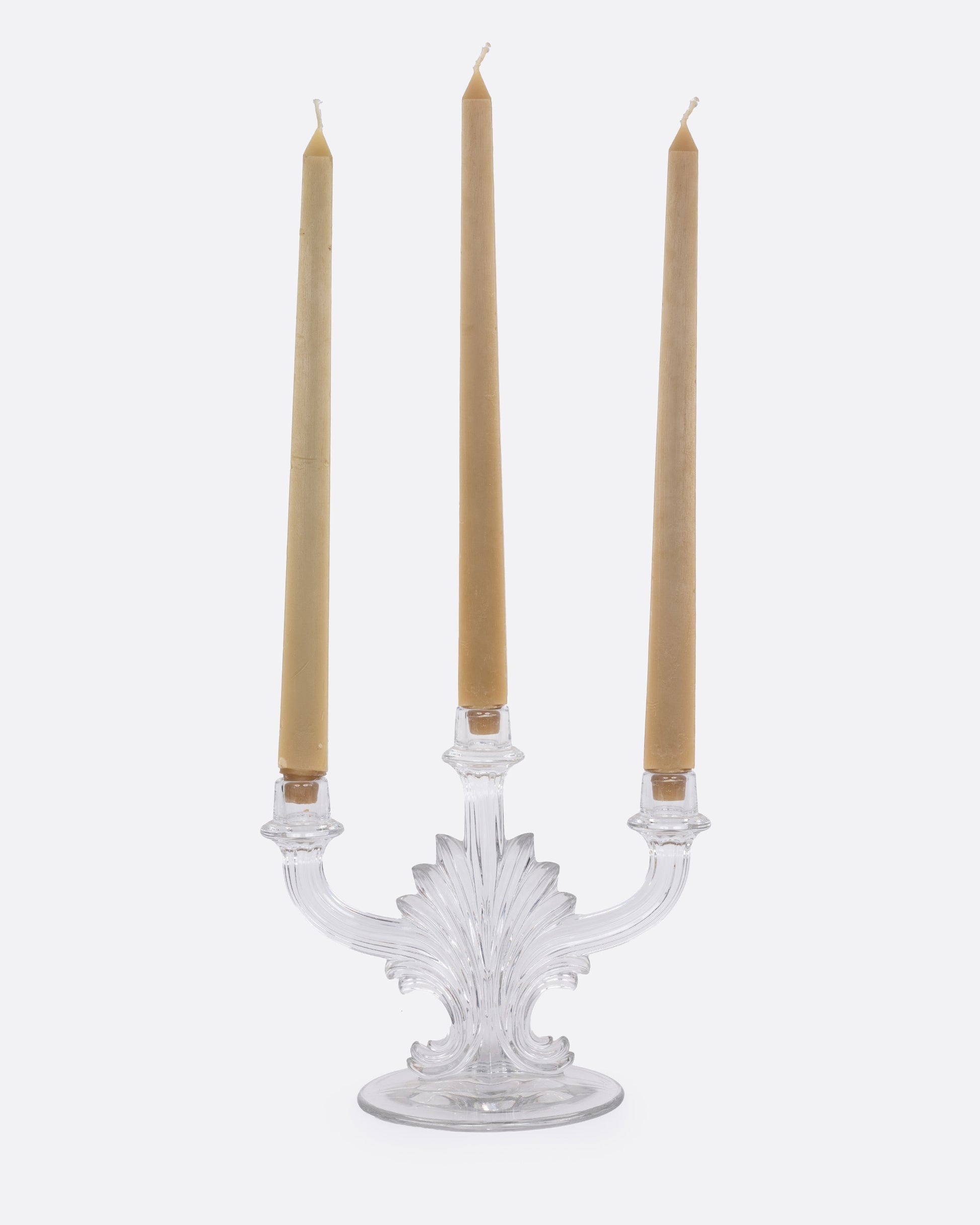 A clear glass candelabra with three holders, shown from the front with candles in each arm.
