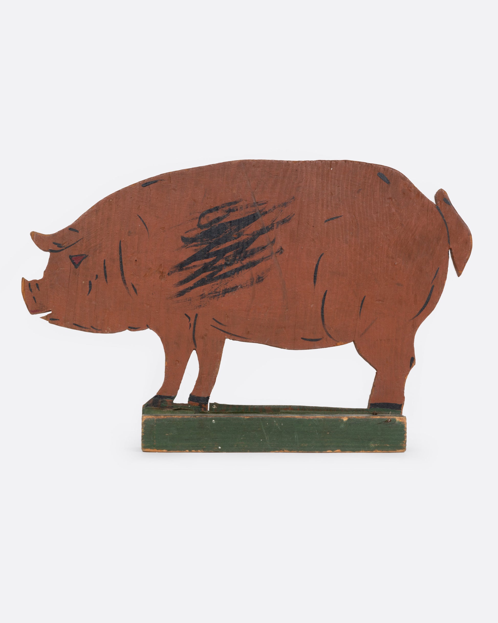 A wooden pig cutout figure, shown from the side.