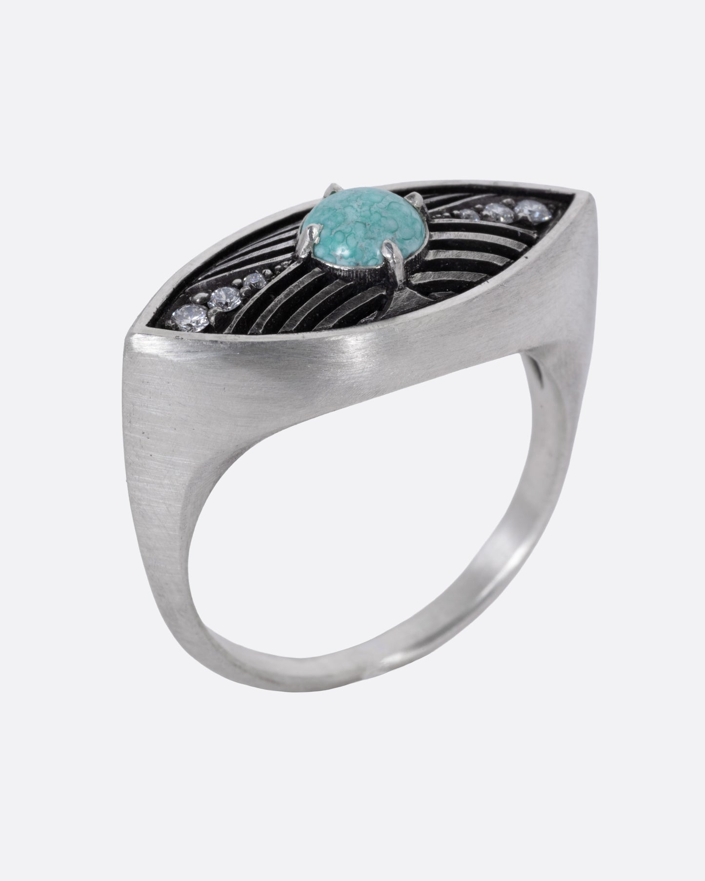 A silver eye shaped ring with a marbled Mexican turquoise cabochon and diamond details, shown from the side standing up.