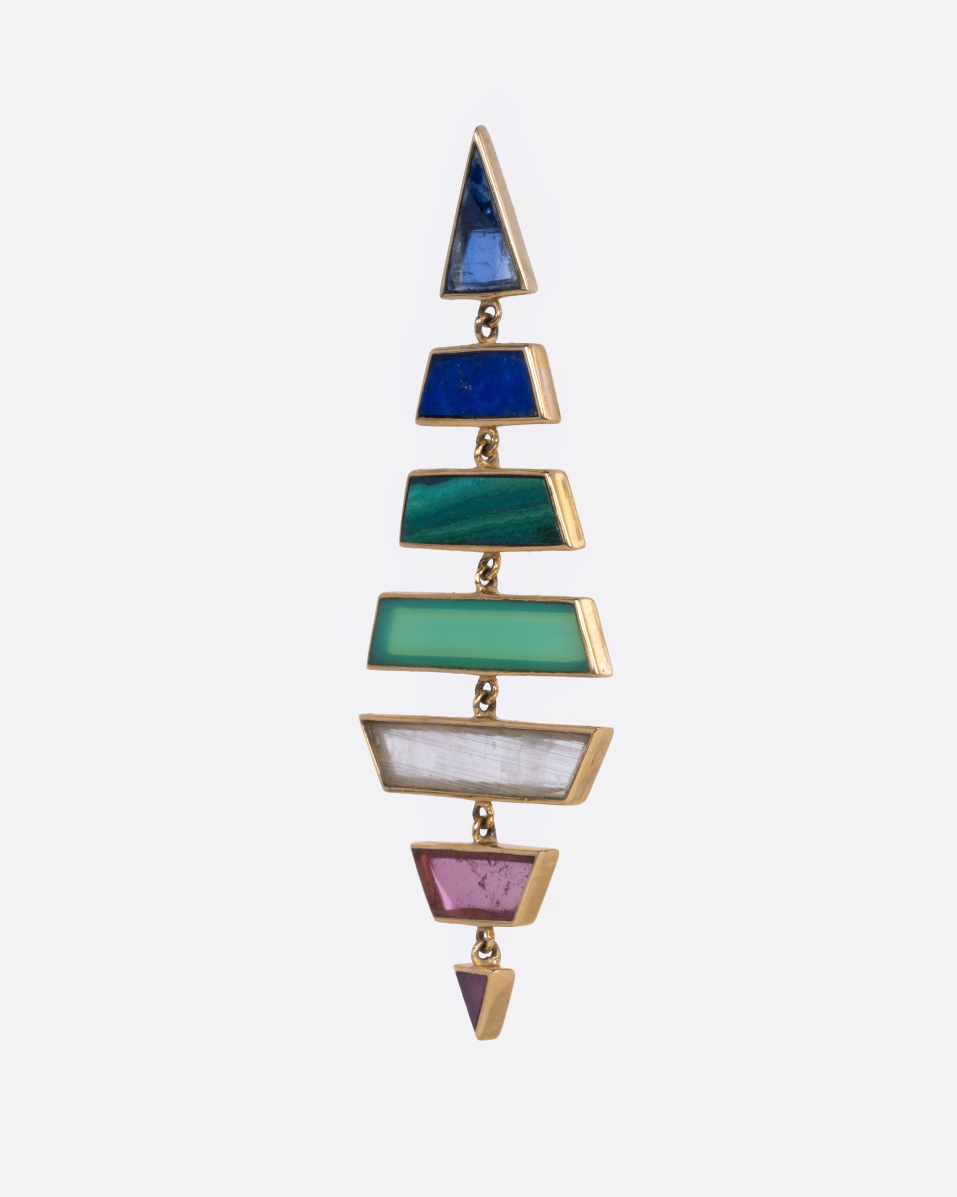 A yellow gold kite shaped drop earring with multi-colored hand cut stones, shown from the side.