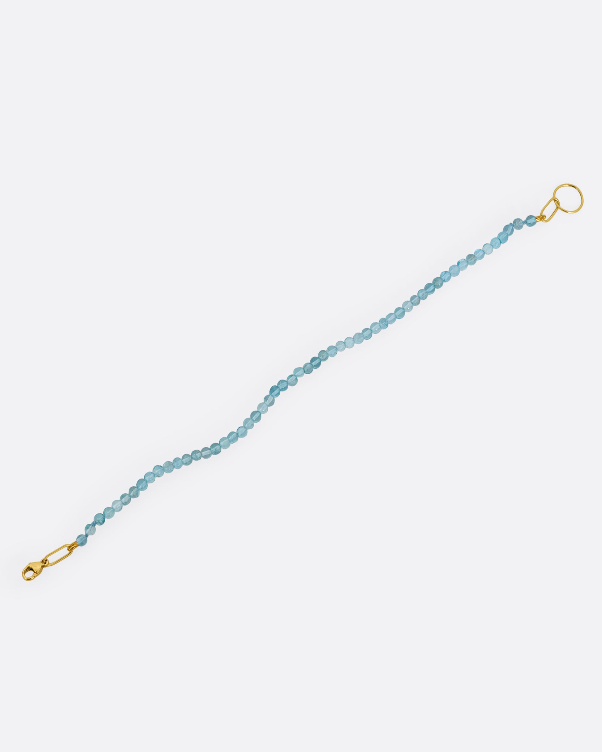  An apatite beaded bracelet with a yellow gold clasp. Shown from the front.