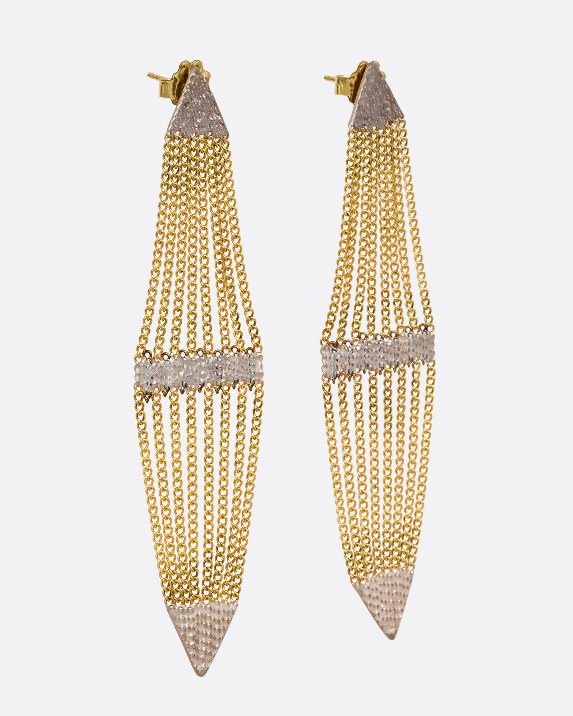 A pair of diamond shaped earrings with silver solder and yellow gold chain. Shown from the side.