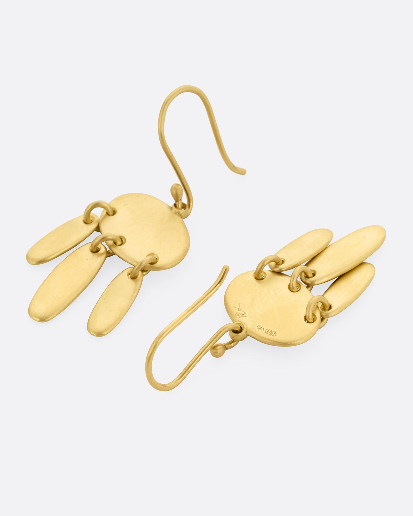 A pair of yellow gold earrings; each with one horizontal oval and  three vertical ovals hanging from links. One earring is shown lying flat from the front, the other from the back.