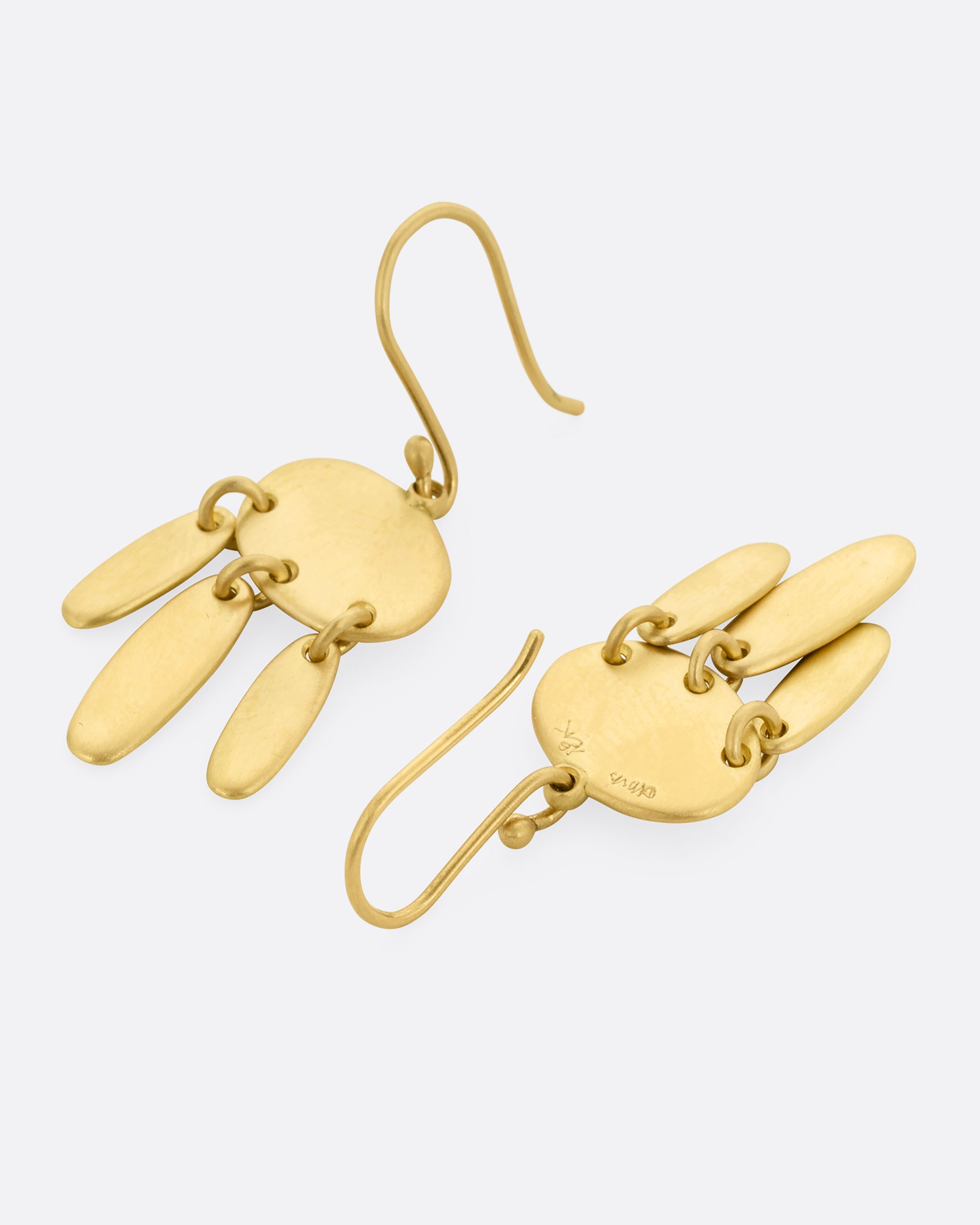 A pair of yellow gold earrings; each with one horizontal oval and  three vertical ovals hanging from links. One earring is shown lying flat from the front, the other from the back.