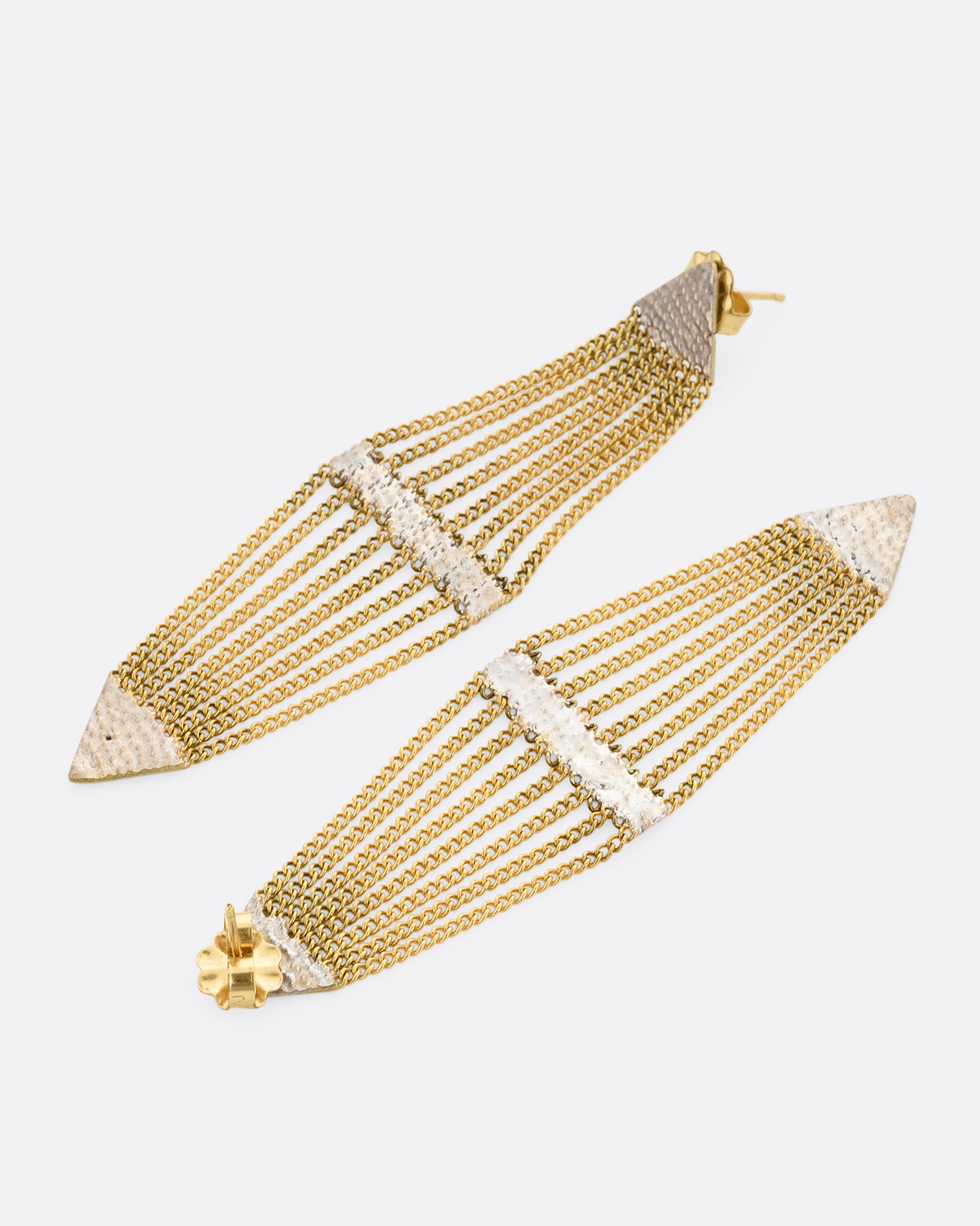 A pair of diamond shaped earrings with silver solder and yellow gold chain. One earring is shown lying flat from the front, the other from the back.