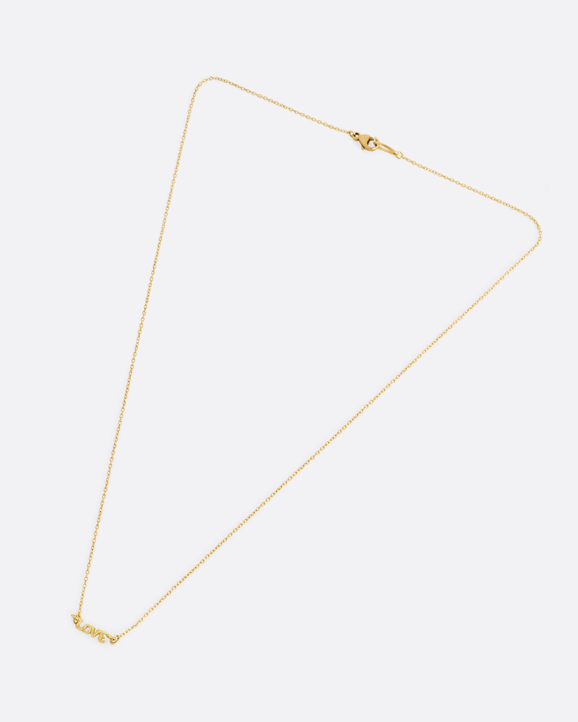 A yellow gold cable chain necklace with a 'LOVE' charm at the center. Shown closed lying flat from the front.