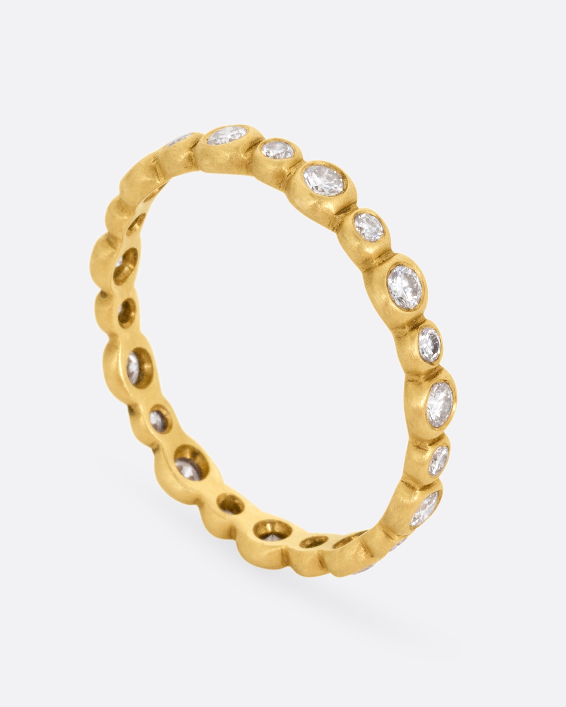  A yellow gold ring with a bubbly pattern of diamonds. Shown standing up from the side.