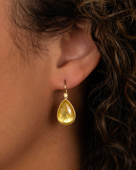 yellow gold yellow tourmaline earrings shown on an ear