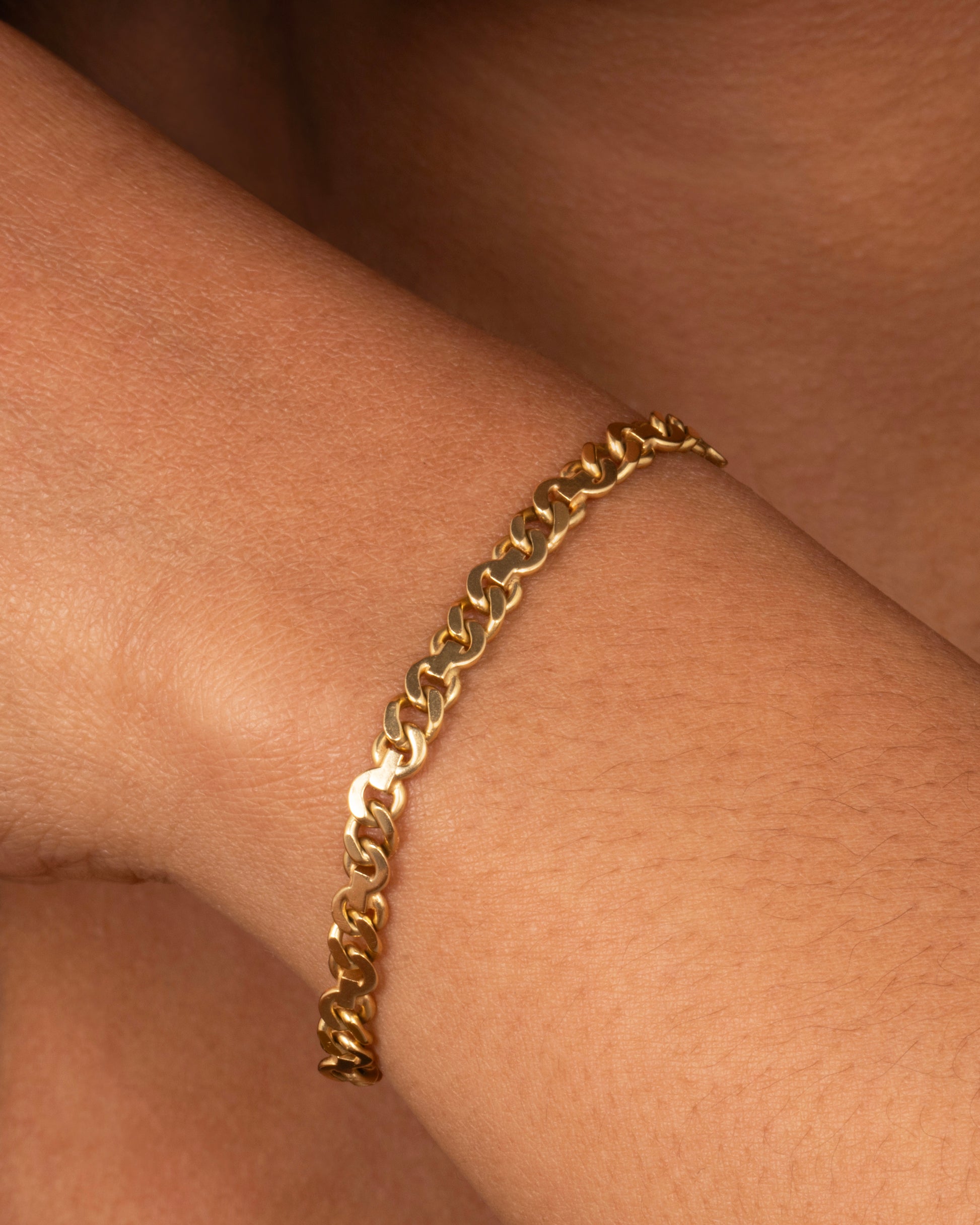 A mixed link yellow gold bracelet. Shown worn on a wrist.